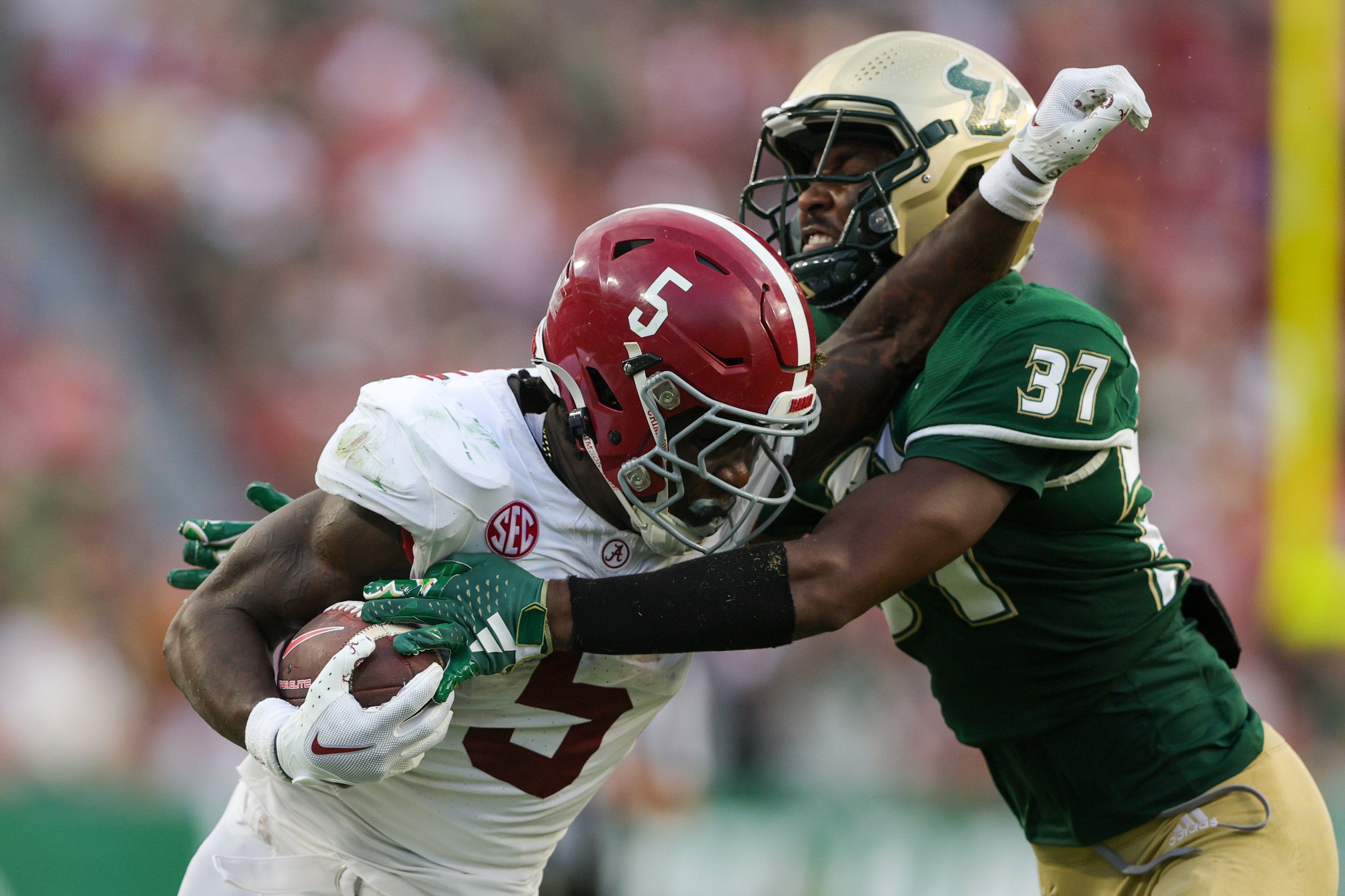 Sep 16, 2023; Tampa, Florida, USA; Alabama Crimson Tide running back Roydell Williams (5) is tackled by South Florida Bulls safety Logan Berryhill (37) in the third quarter at Raymond James Stadium. Mandatory Credit: Nathan Ray Seebeck-Imagn Images