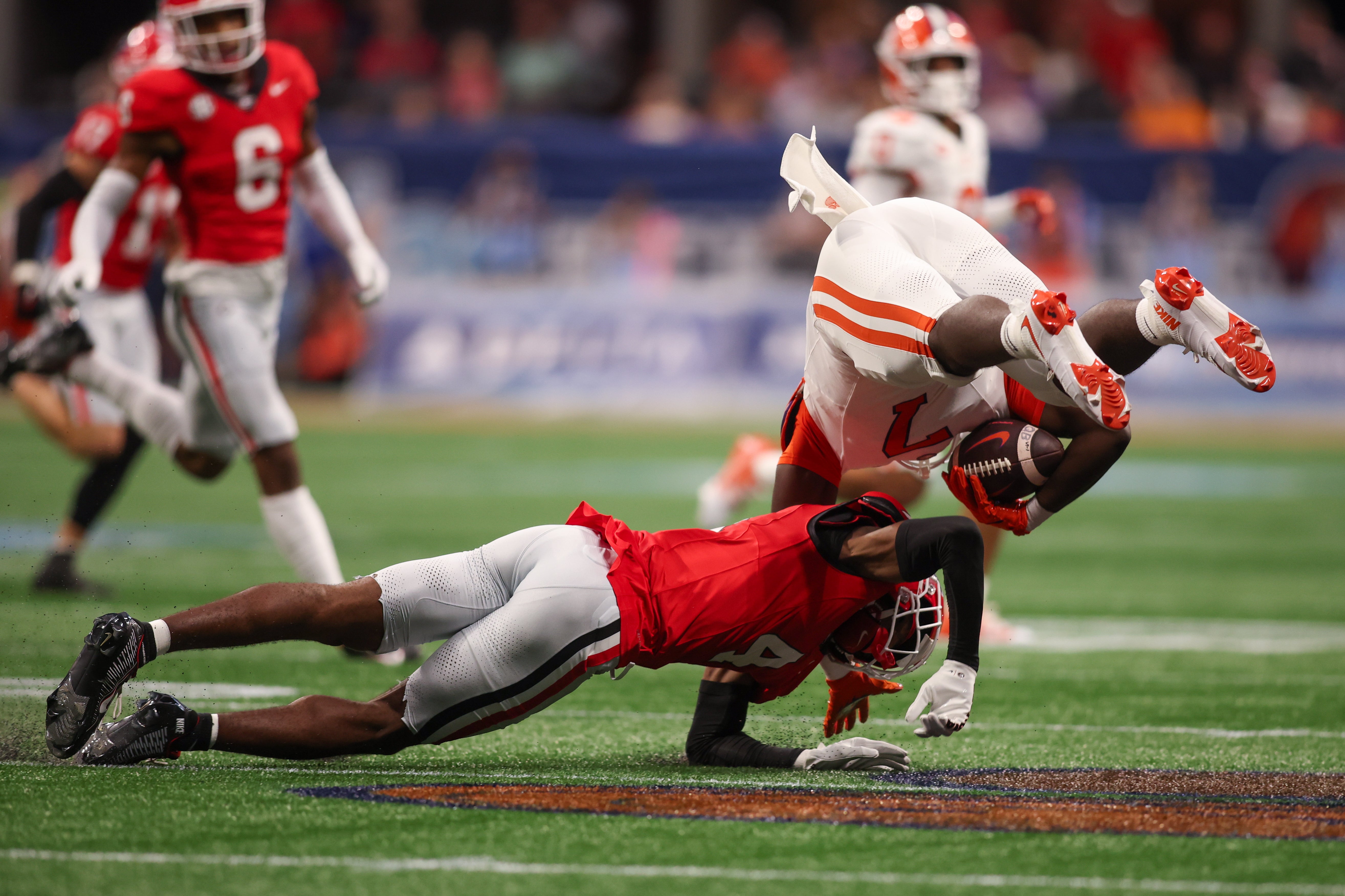 Georgia Bulldogs defensive back KJ Bolden (4) tackles Clemson Tigers running back Phil Mafah (7) in the first quarter at Mercedes-Benz Stadium.
