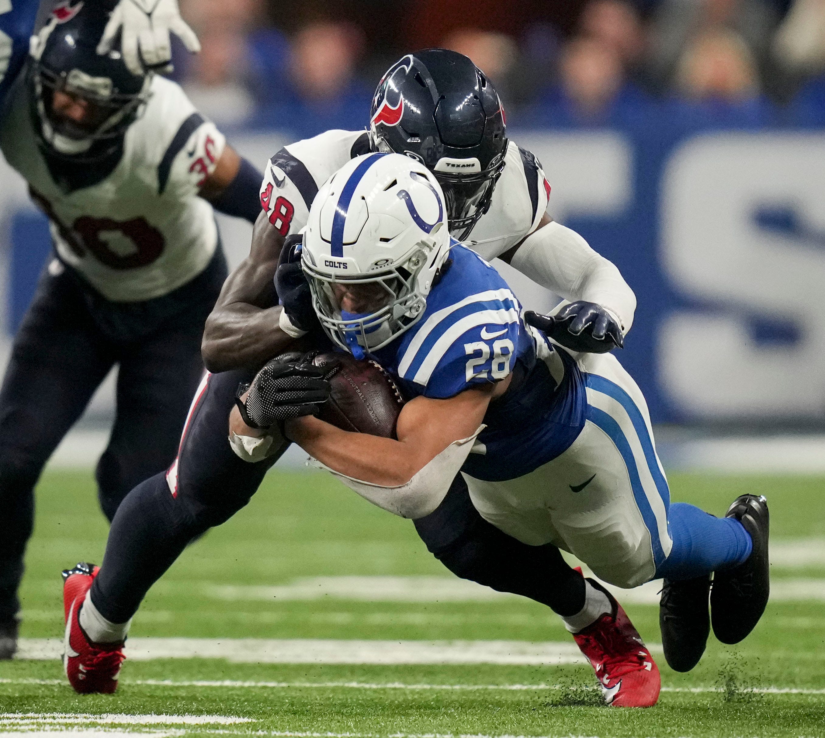 Houston Texans linebacker Christian Harris (48) brings down Indianapolis Colts running back Jonathan Taylor (28) on Saturday, Jan. 6, 2024, during a game against the Houston Texans at Lucas Oil Stadium in Indianapolis.