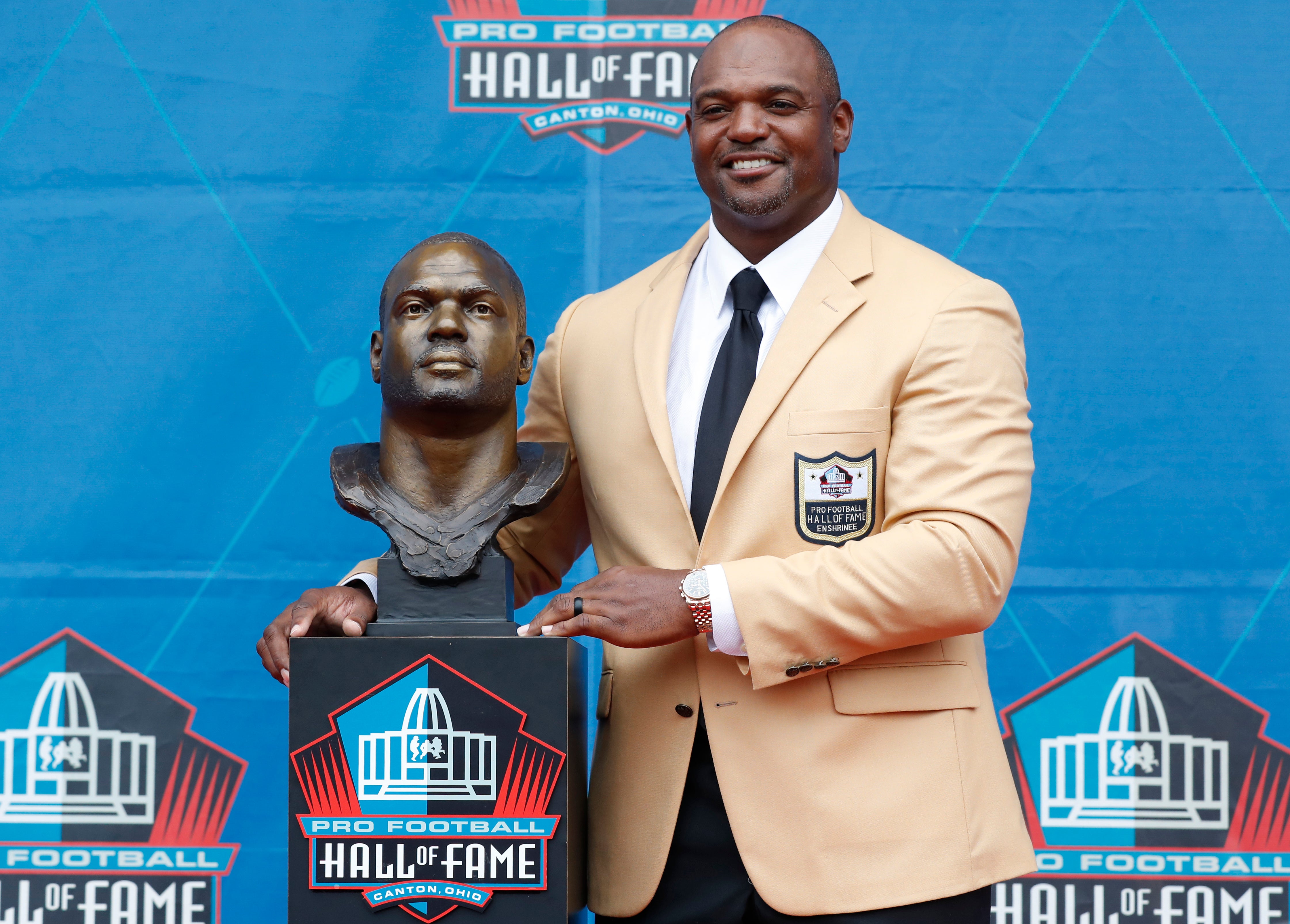 Aug 3, 2024; Canton, OH, USA; Pro Football Hall of Fame Class of 2024 member Dwight Freeney poses with his bust at his enshrinement ceremony at Tom Benson Hall of Fame Stadium.