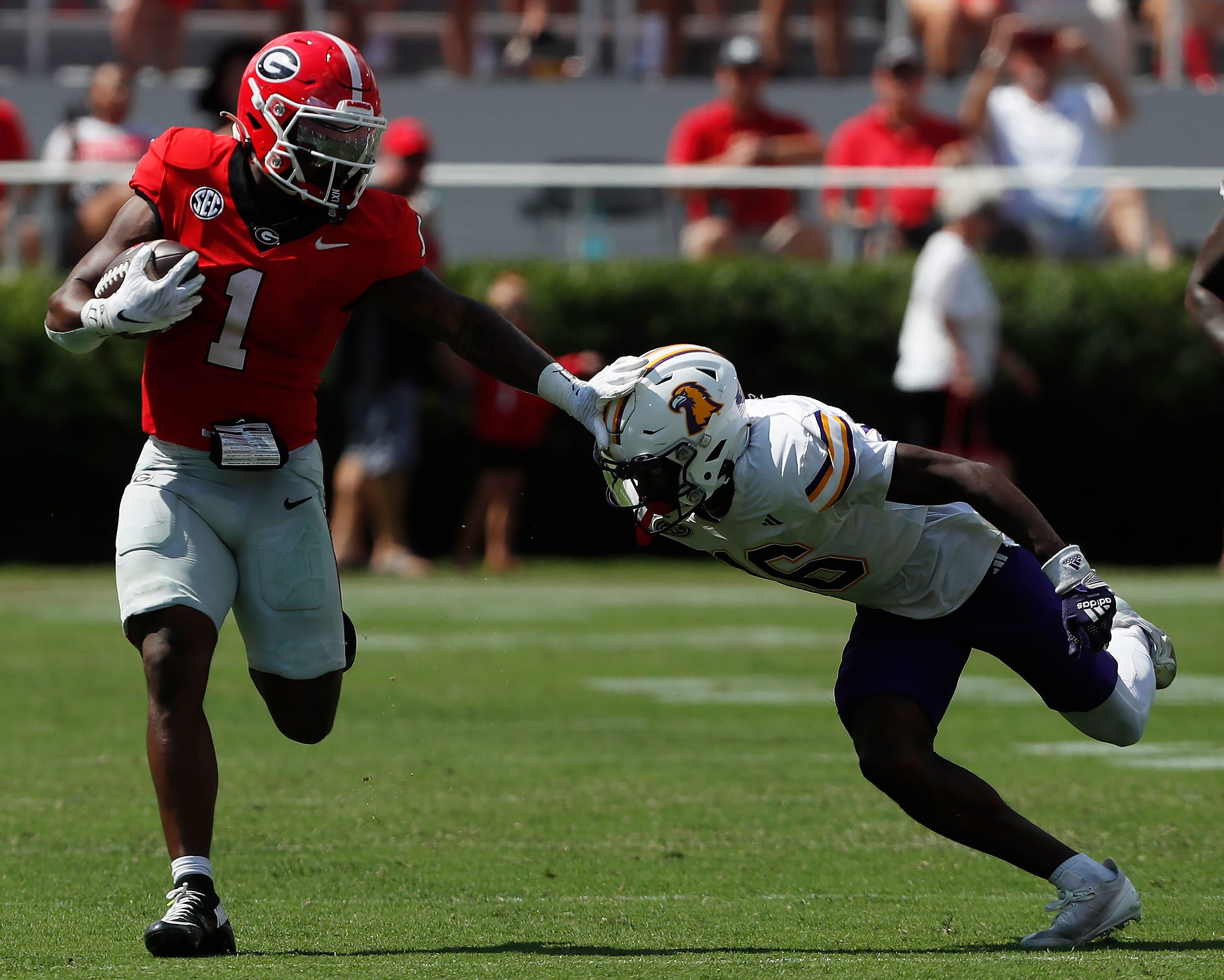 Georgia running back Trevor Etienne (1) stiff-arms Tennessee Tech defensive back Omari Philyaw (16) during the first half of a NCAA college football game in Athens, Ga., on Saturday, Sept. 7, 2024