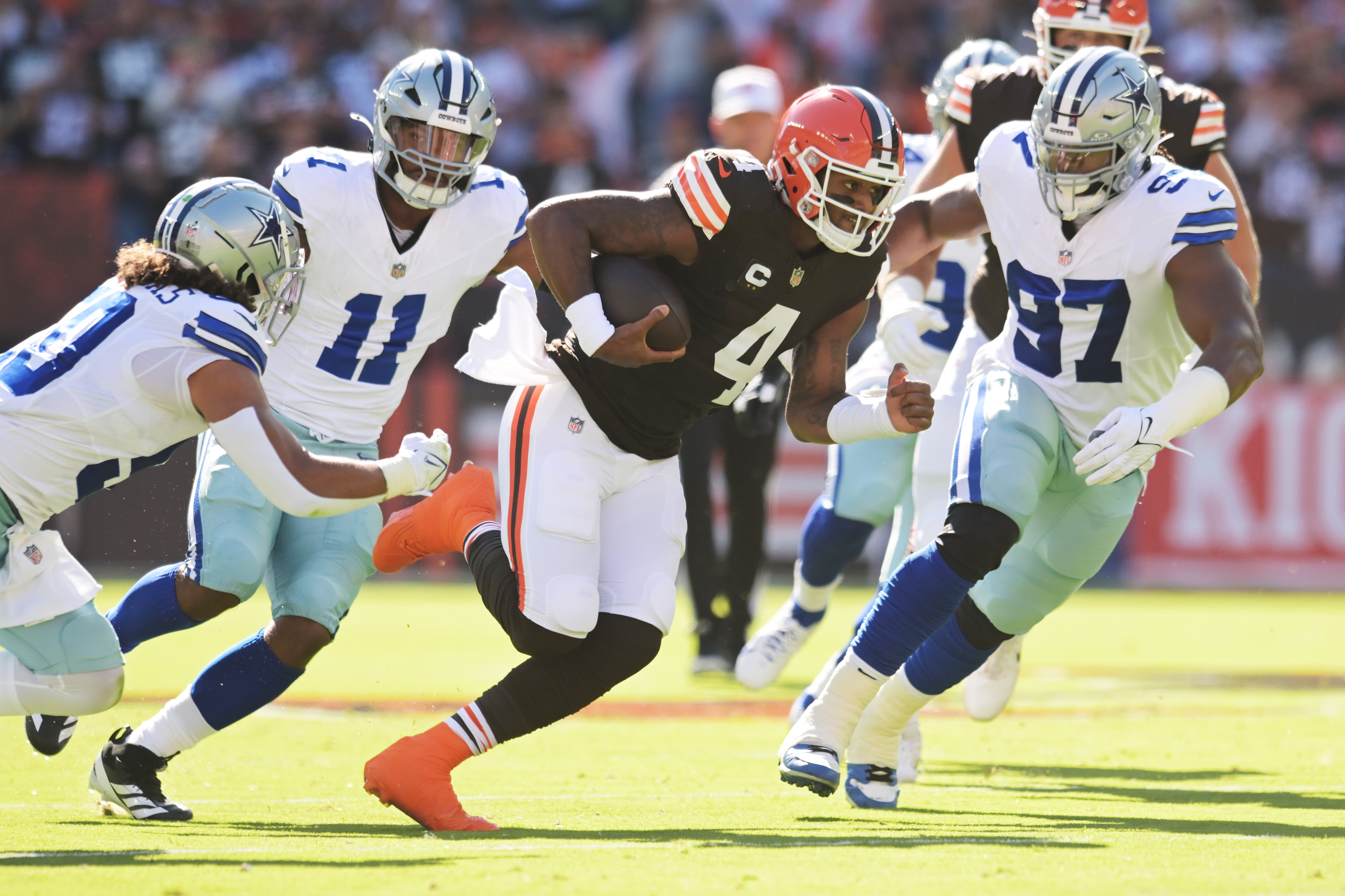 Cleveland Browns quarterback Deshaun Watson (4) runs from the Dallas Cowboys defense during the first quarter at Huntington Bank Field.