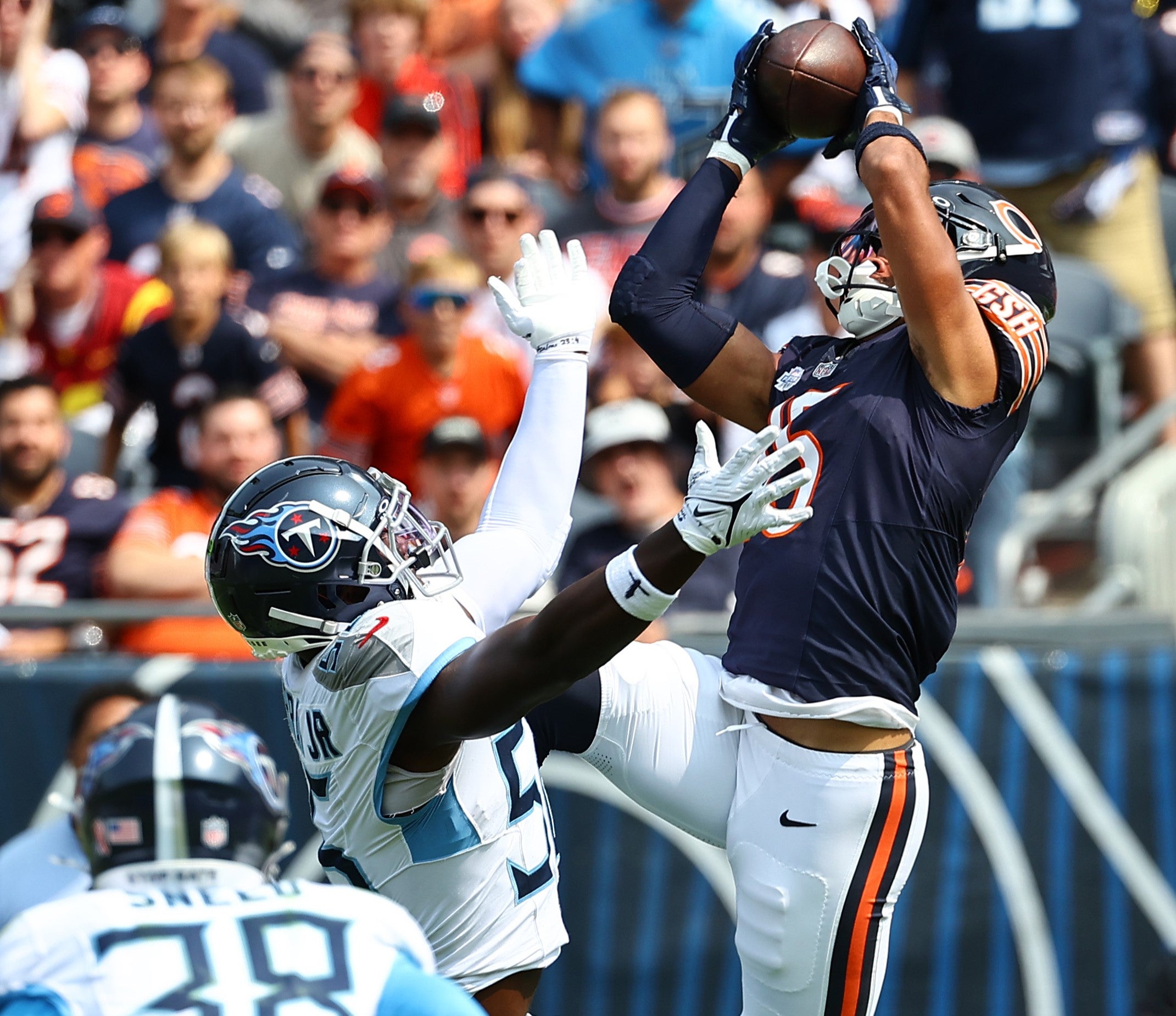 Sep 8, 2024; Chicago, Illinois, USA; Chicago Bears wide receiver Rome Odunze (15) makes a catch over Tennessee Titans linebacker Kenneth Murray Jr. (56) during the second quarter at Soldier Field.