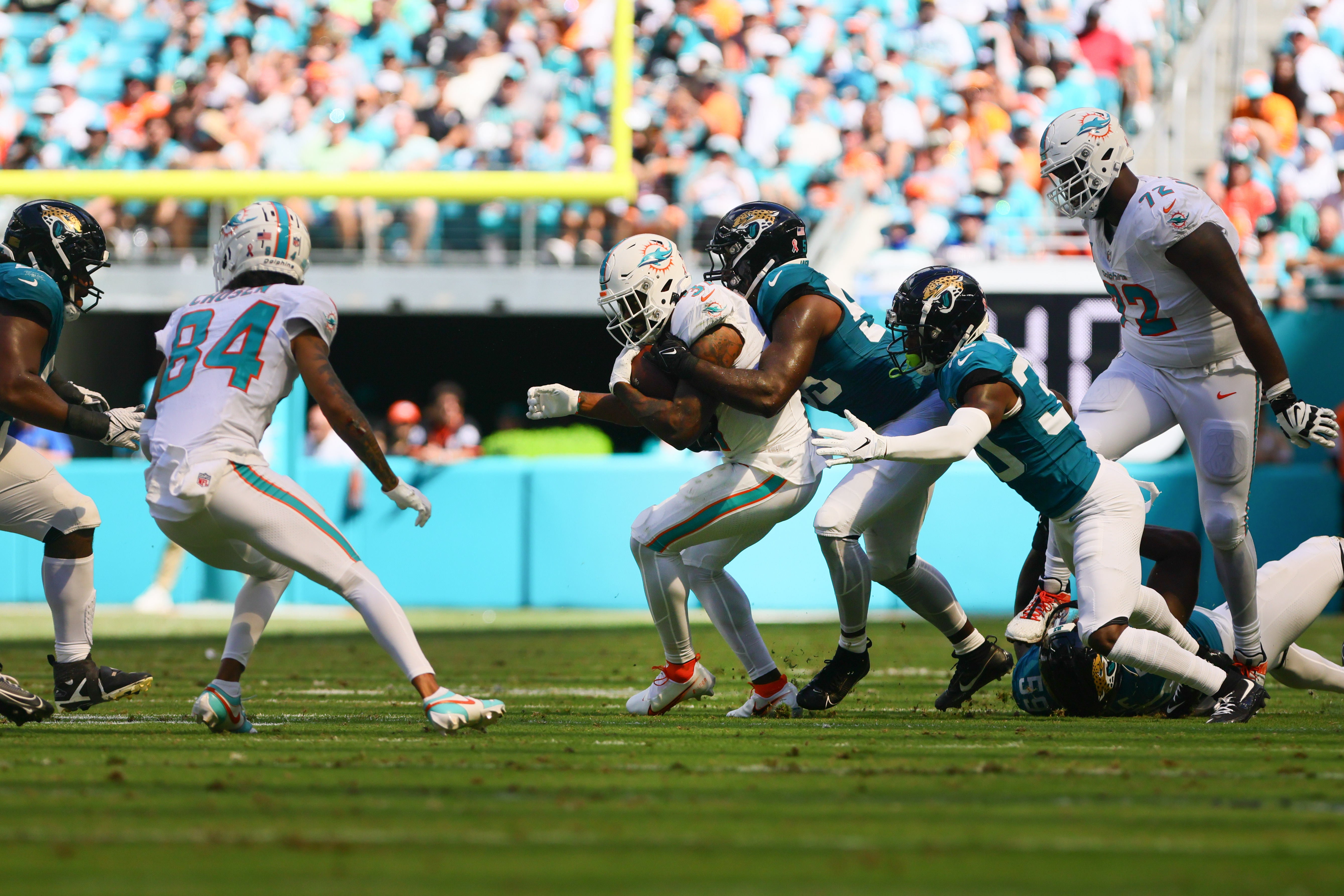 Sep 8, 2024; Miami Gardens, Florida, USA; Miami Dolphins running back Raheem Mostert (31) runs with the football against Jacksonville Jaguars linebacker Yasir Abdullah (56) and cornerback Montaric Brown (30) during the fourth quarter at Hard Rock Stadium.
