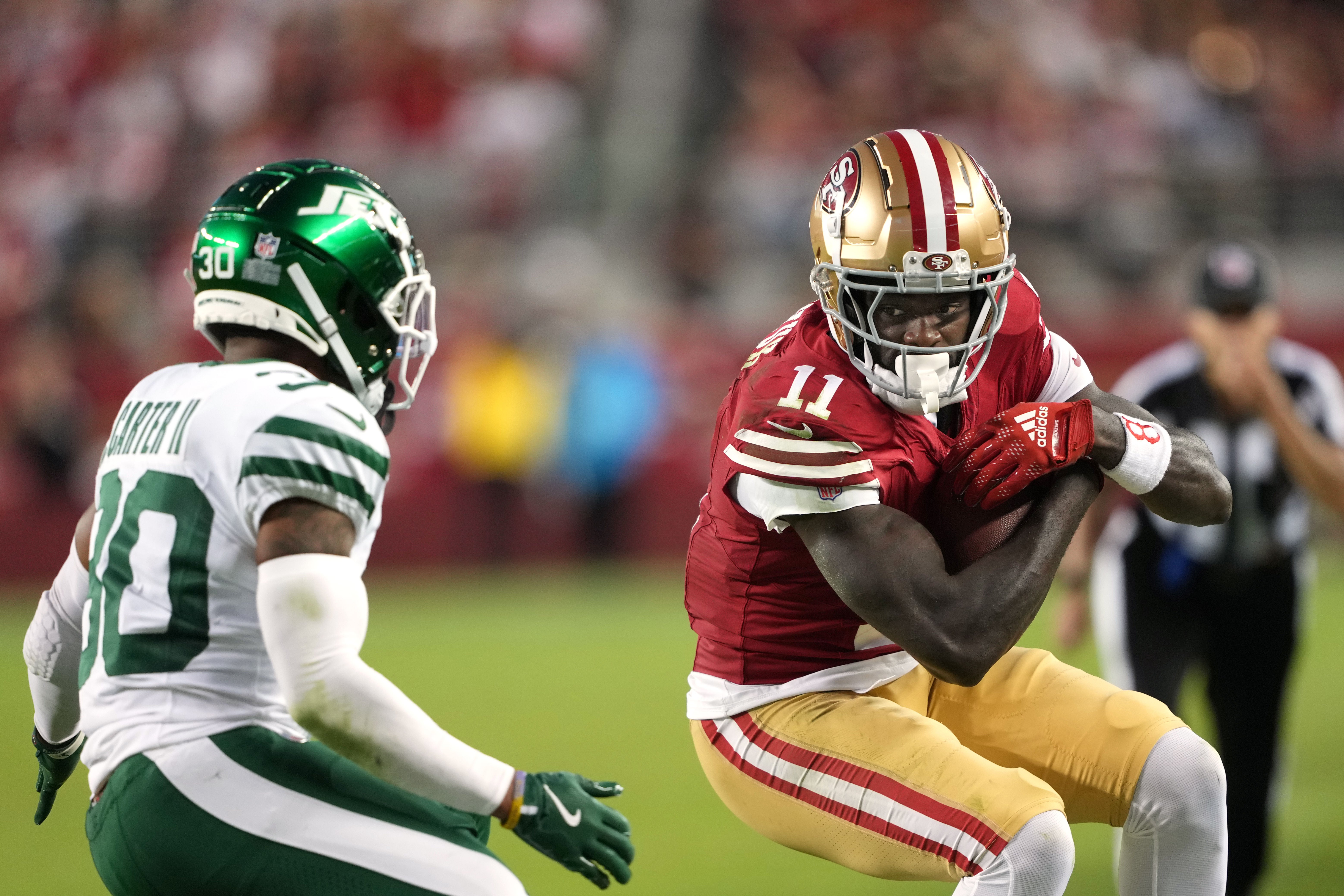 Sep 9, 2024; Santa Clara, California, USA; San Francisco 49ers wide receiver Brandon Aiyuk (11) runs after a catch against New York Jets cornerback Michael Carter II (left) during the fourth quarter at Levi's Stadium.