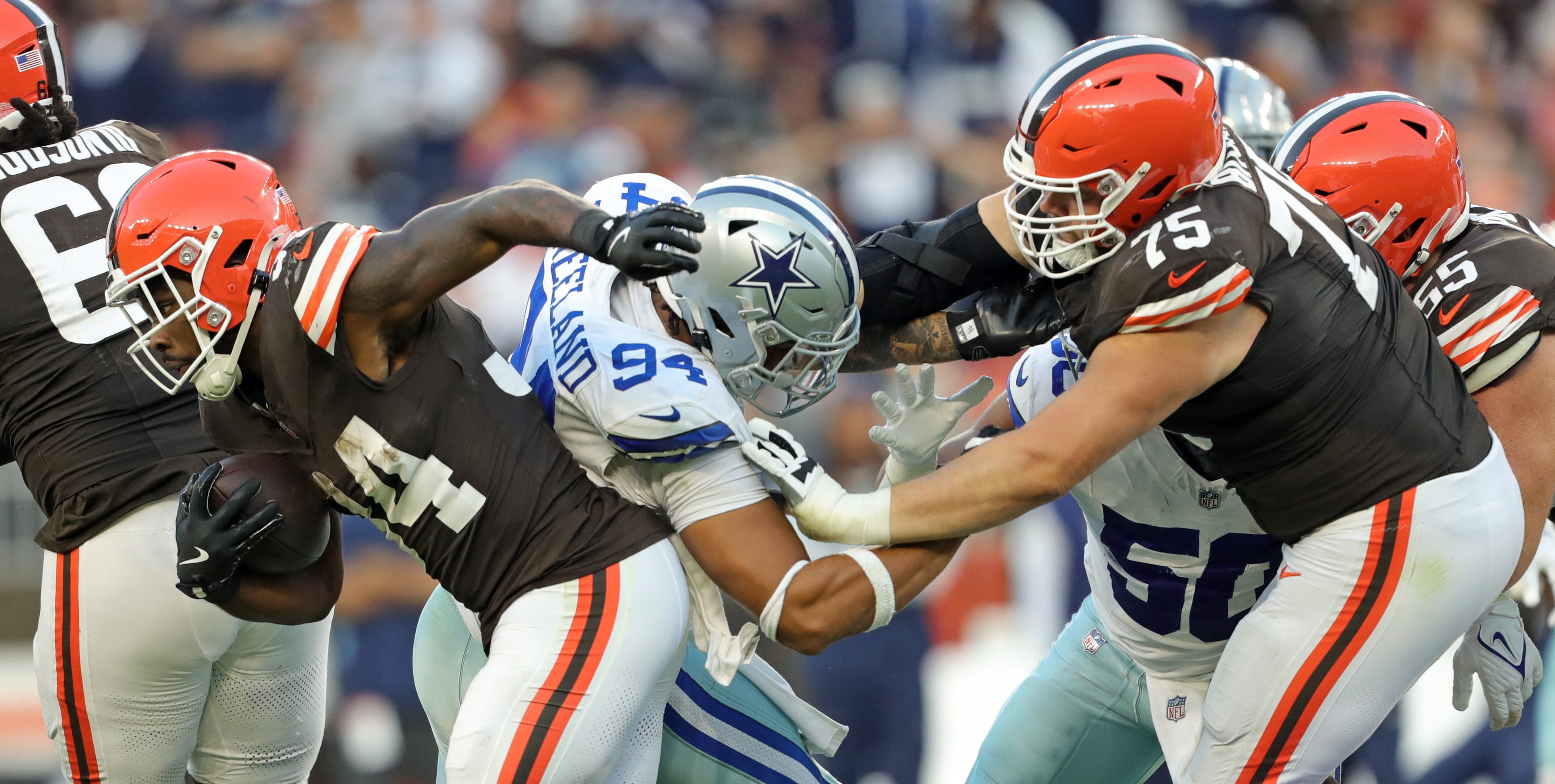 Cleveland Browns running back Jerome Ford (34) runs for a short gain as guard Joel Bitonio (75) shoves Dallas Cowboys defensive end Marshawn Kneeland (94) into him during the second half of an NFL football game at Huntington Bank Field, Sunday, Sept. 8, 2024, in Cleveland, Ohio.