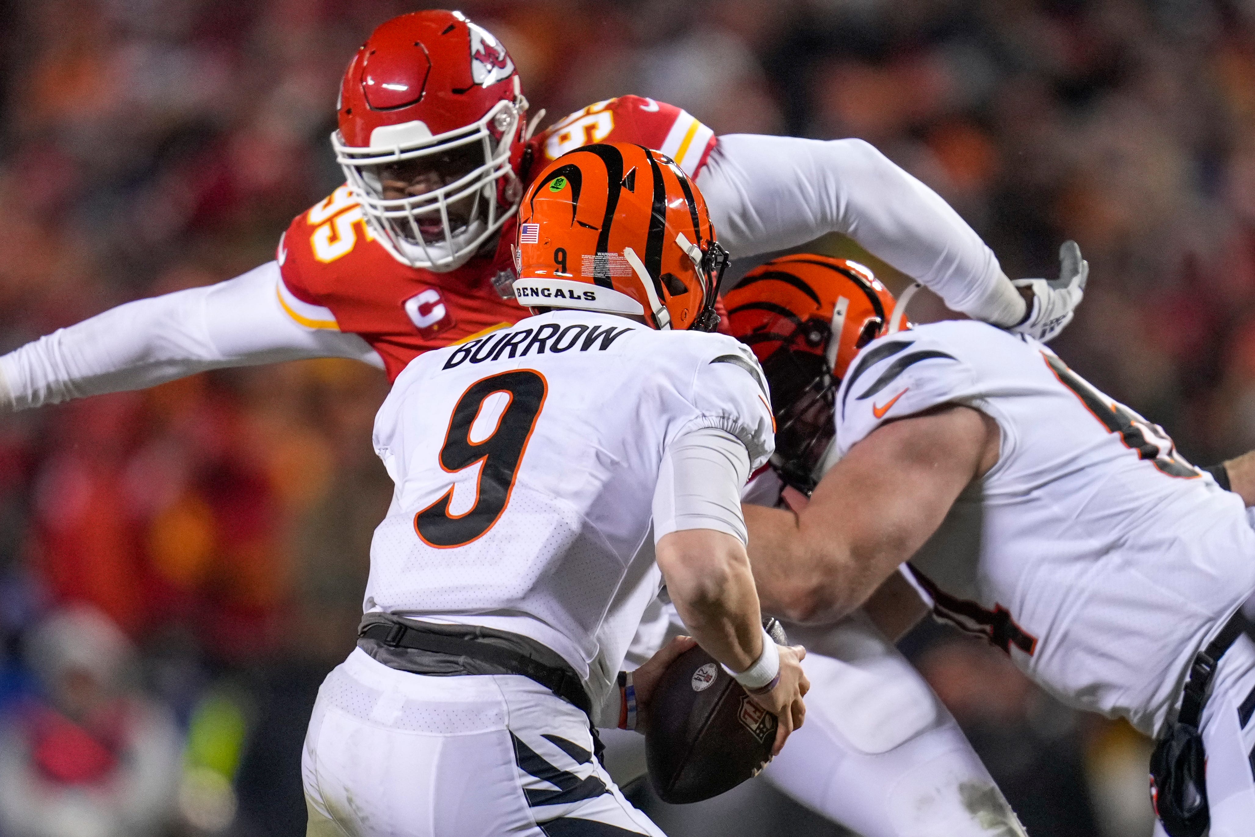 Jan 30, 2022; Kansas City, Missouri, USA; Cincinnati Bengals quarterback Joe Burrow (9) runs with the ball as Kansas City Chiefs defensive end Chris Jones (95) gives chase during the fourth quarter of the AFC Championship Game at GEHA Field at Arrowhead Stadium.
