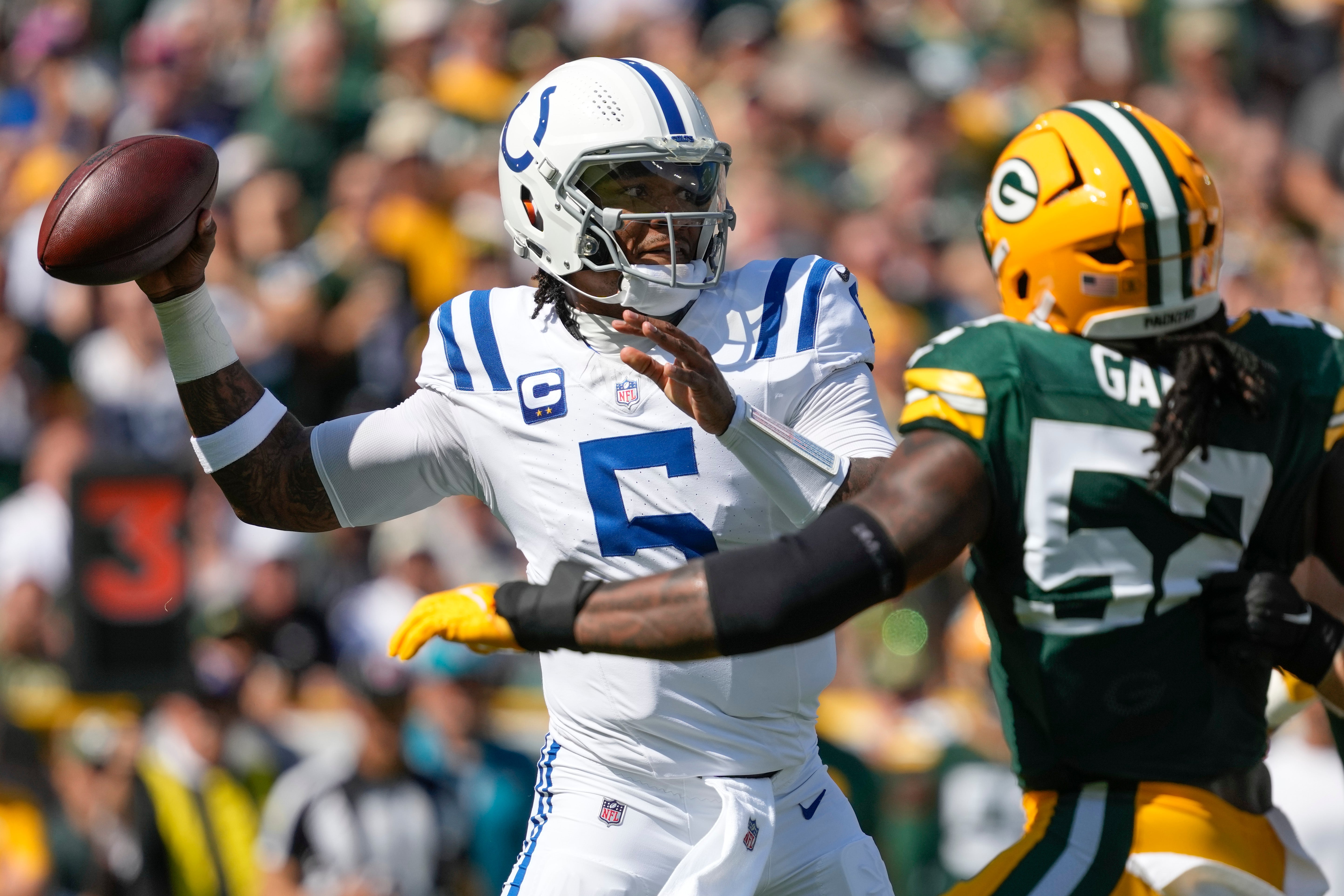 Sep 15, 2024; Green Bay, Wisconsin, USA; Indianapolis Colts quarterback Anthony Richardson (5) throws a pass under pressure from Green Bay Packers defensive lineman Rashan Gary (52) during the first quarter at Lambeau Field.