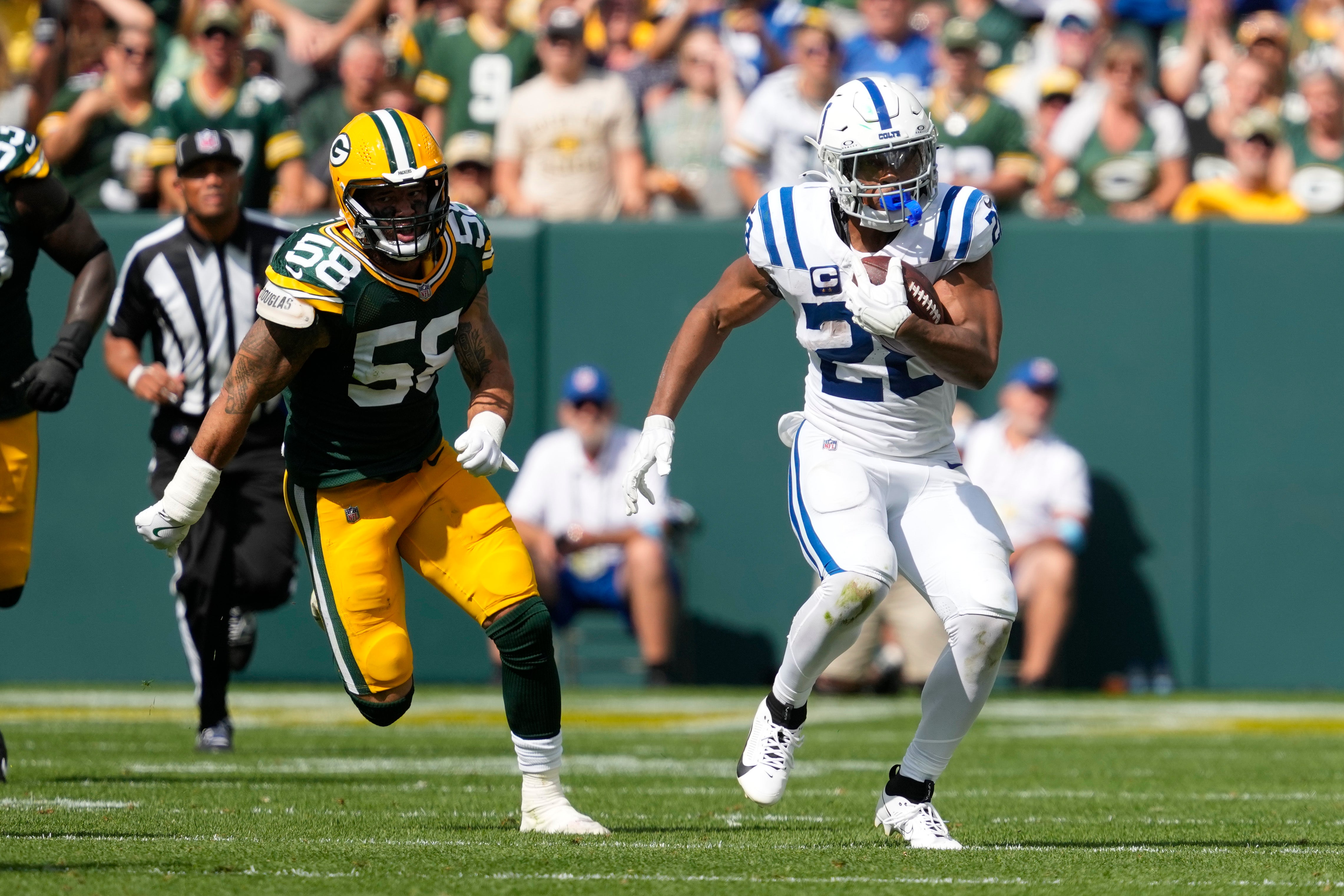 Sep 15, 2024; Green Bay, Wisconsin, USA; Indianapolis Colts running back Jonathan Taylor (28) rushes with the football in front of Green Bay Packers linebacker Isaiah McDuffie (58) during the third quarter at Lambeau Field.