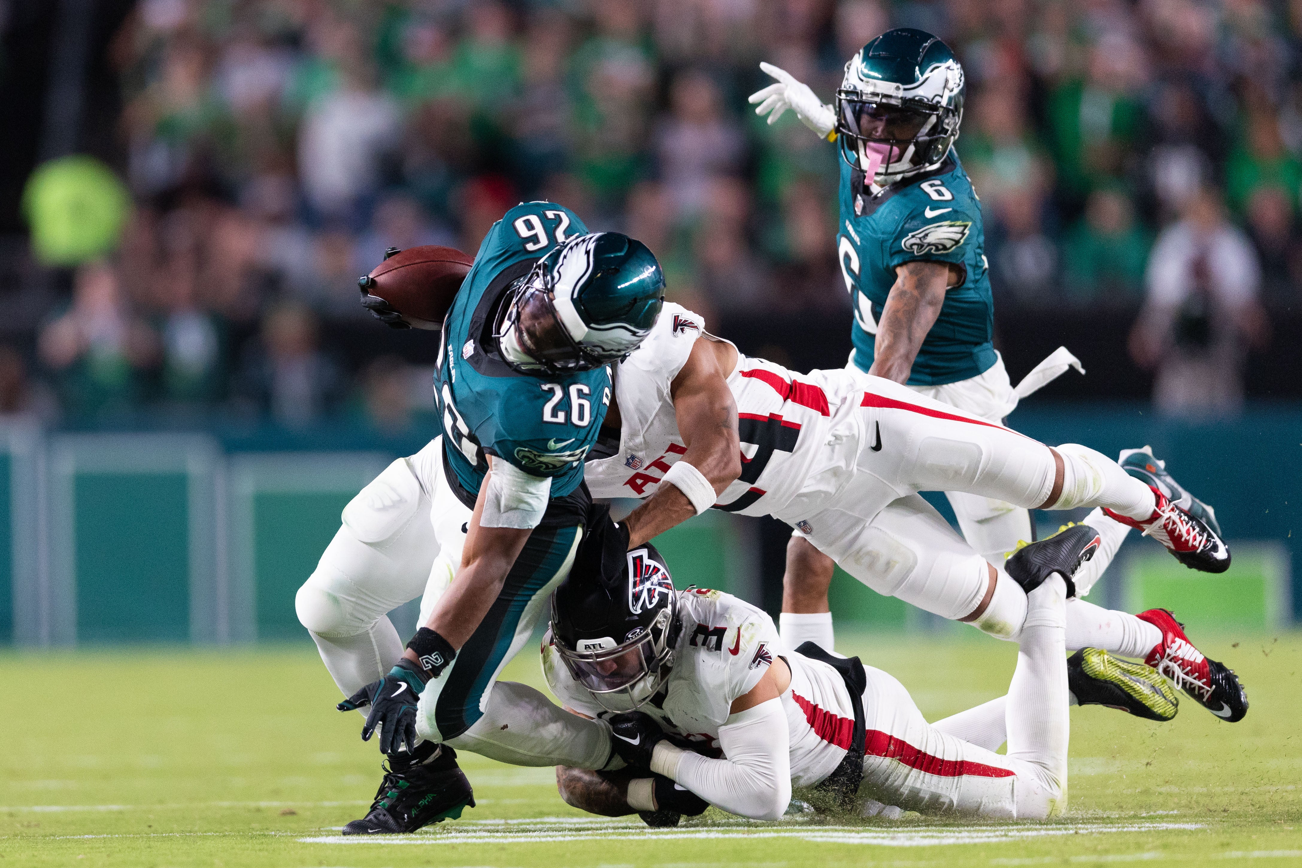 Philadelphia Eagles running back Saquon Barkley (26) is tackled by Atlanta Falcons safety Jessie Bates III (3) and cornerback A.J. Terrell (24) during the fourth quarter at Lincoln Financial Field.