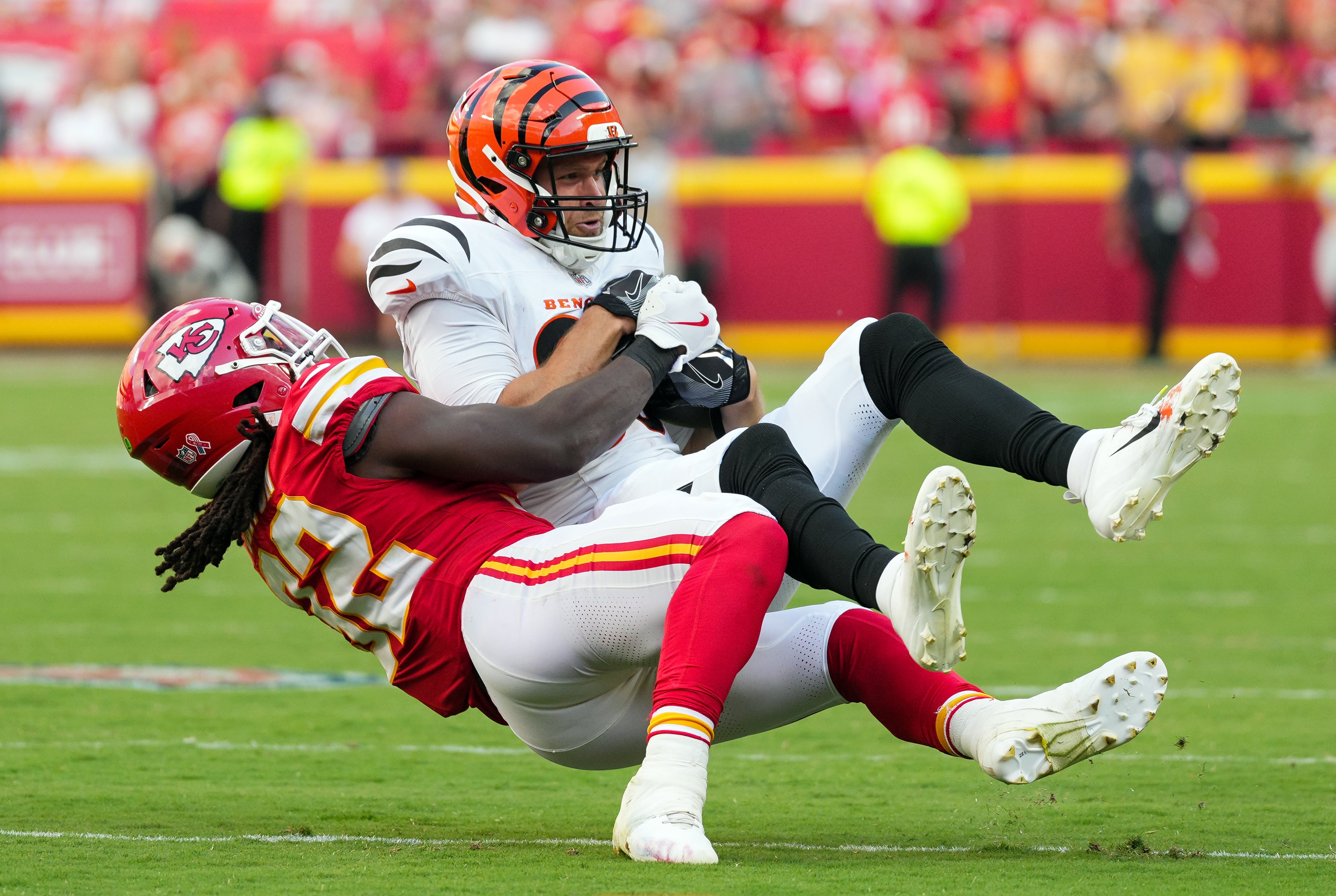 Sep 15, 2024; Kansas City, Missouri, USA; Cincinnati Bengals tight end Mike Gesicki (88) is tackled by Kansas City Chiefs linebacker Nick Bolton (32) during the second half at GEHA Field at Arrowhead Stadium.
