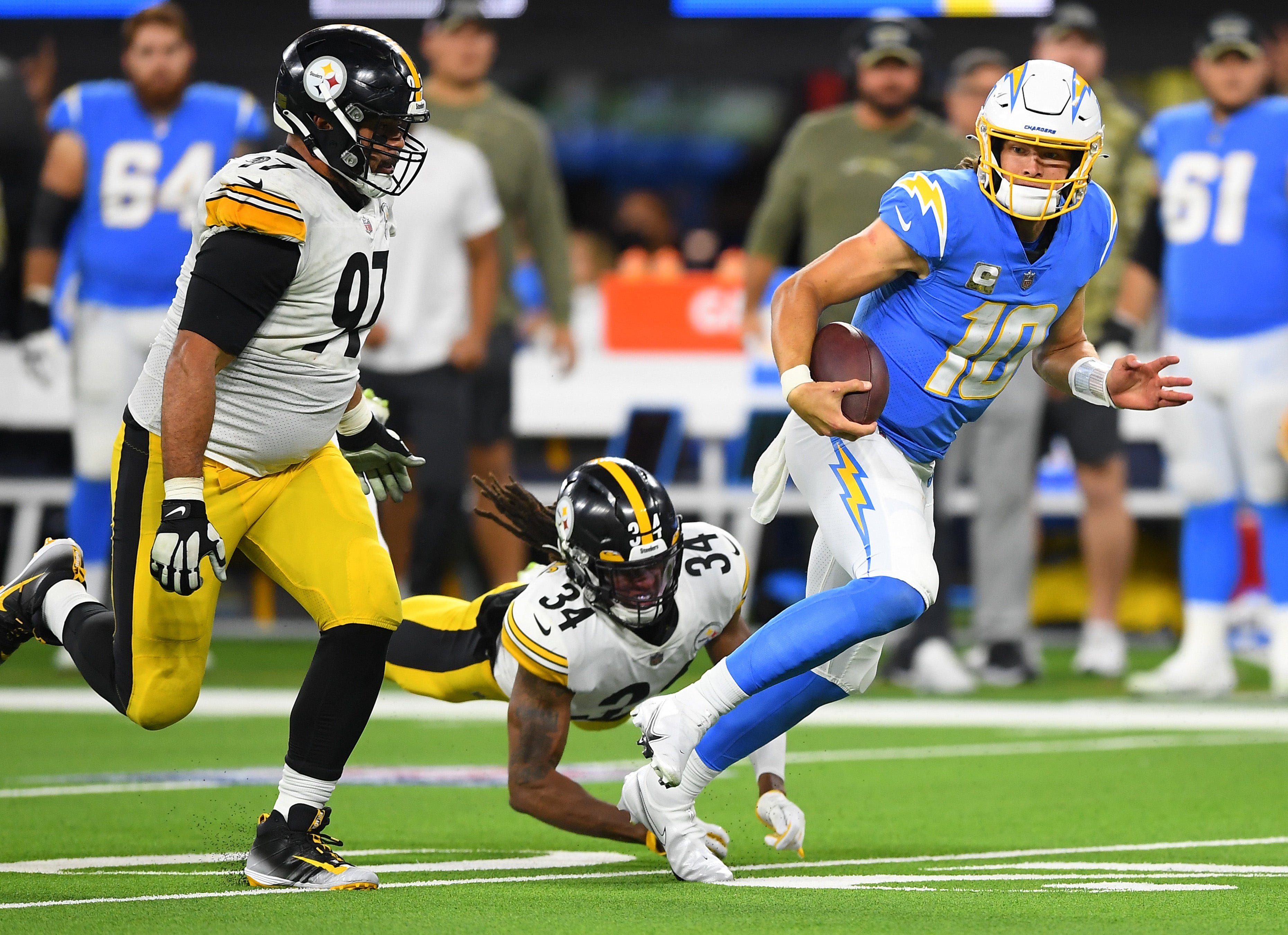 Nov 21, 2021; Inglewood, California, USA; Los Angeles Chargers quarterback Justin Herbert (10) gets past Pittsburgh Steelers safety Terrell Edmunds (34) and defensive end Cameron Heyward (97) as he runs for a first down in the second half the game at SoFi Stadium. Mandatory Credit: Jayne Kamin-Oncea-Imagn Images