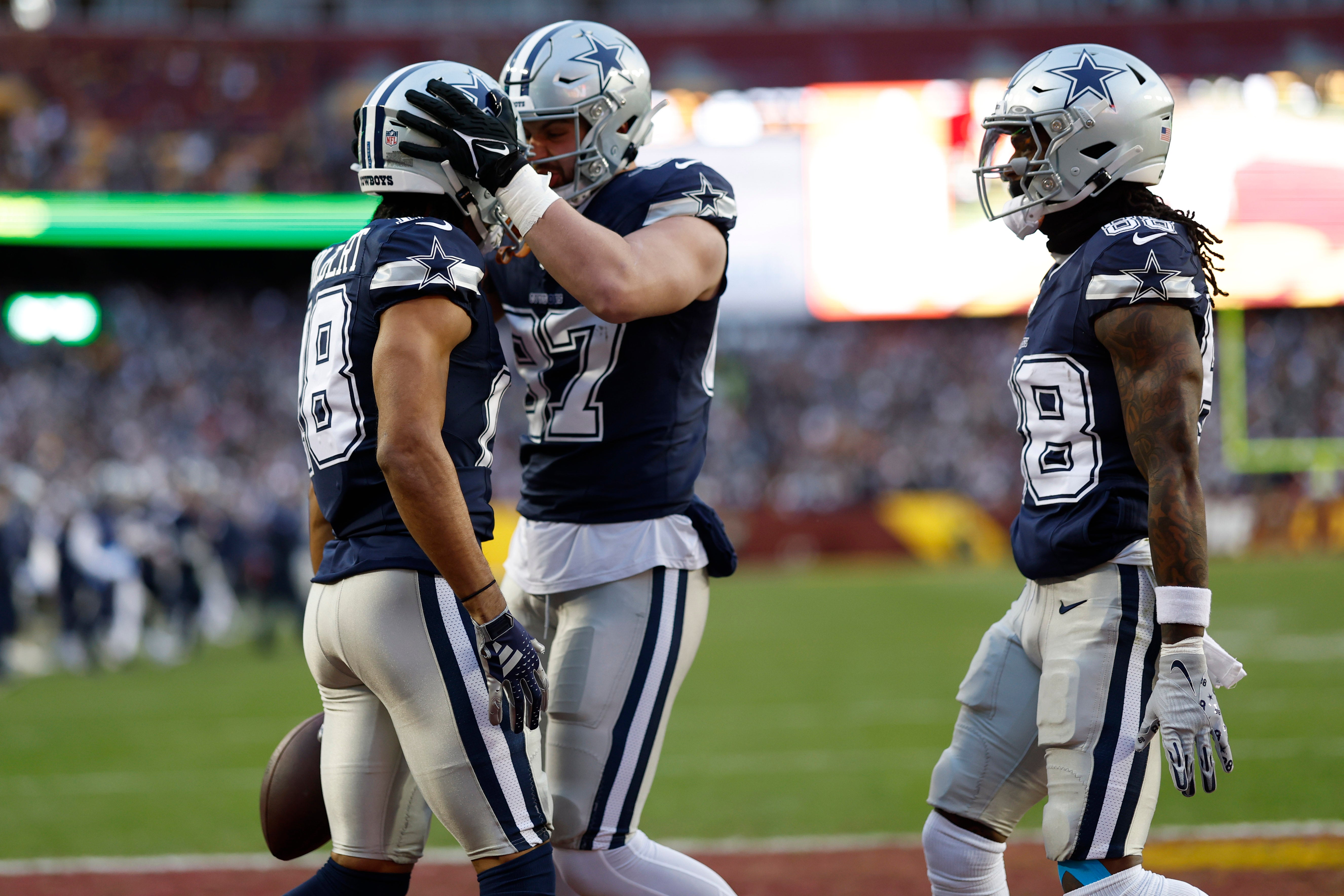 Dallas Cowboys wide receiver Jalen Tolbert (18) celebrates with Cowboys tight end Jake Ferguson (87) after catching a touchdown pass against the Washington Commanders during the first quarter at FedExField.