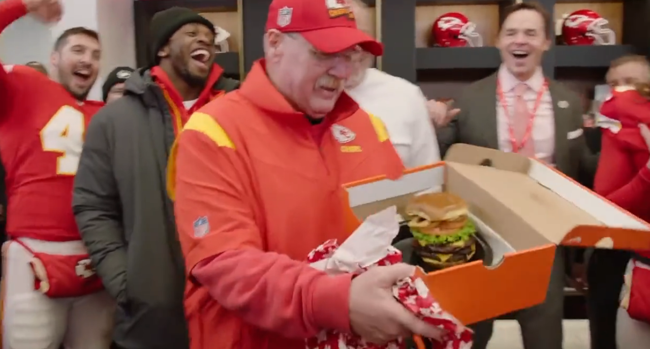 Chiefs HC Andy Reid is gifted a cheeseburger after a win in Dec. of 2022.
