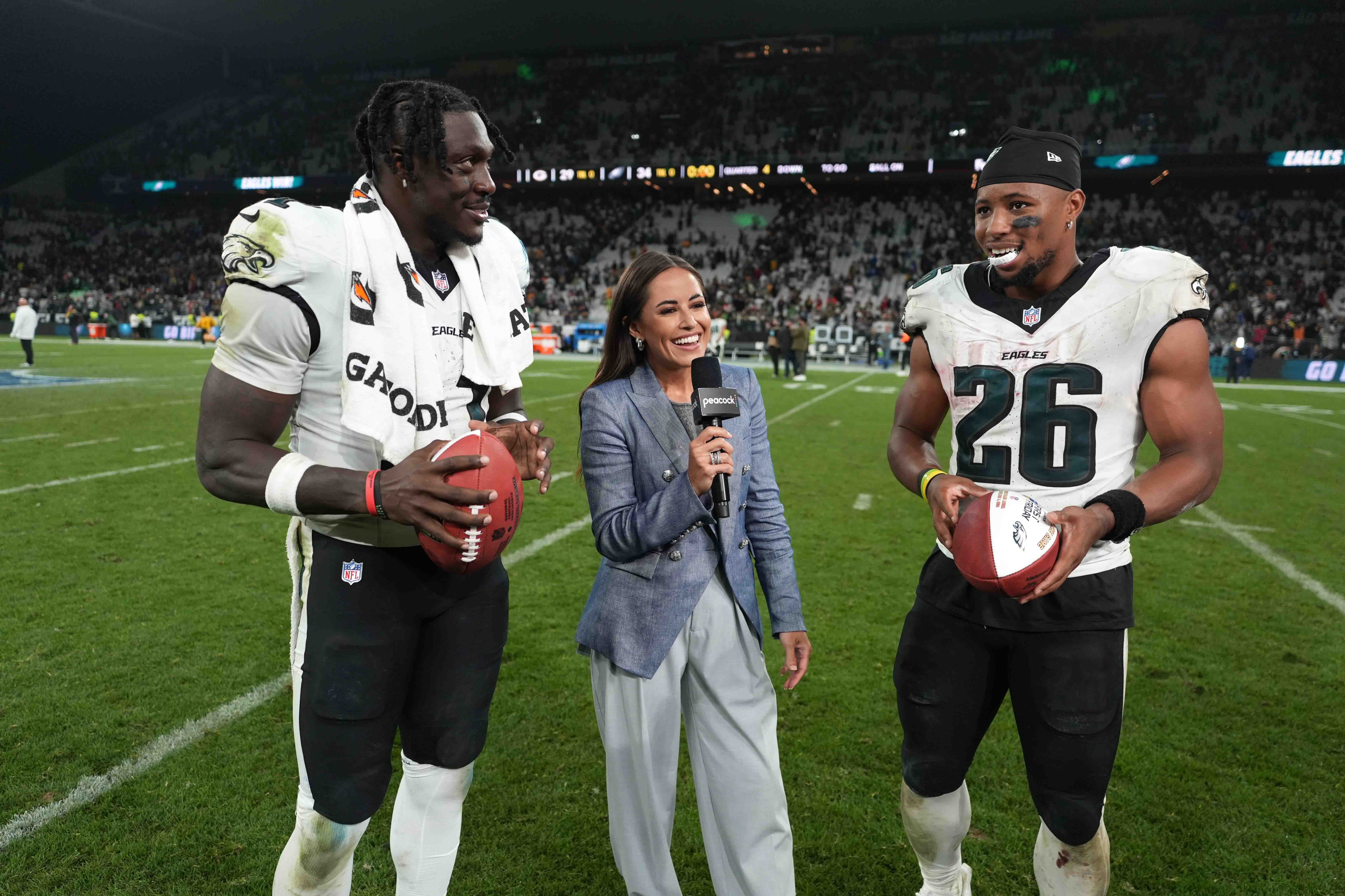Peacock sideline reporter Kaylee Hartung (center) interviews Philadelphia Eagles wide receiver A.J. Brown (11) and running back Saquon Barkley (26) after the 2024 NFL Sao Paolo Game