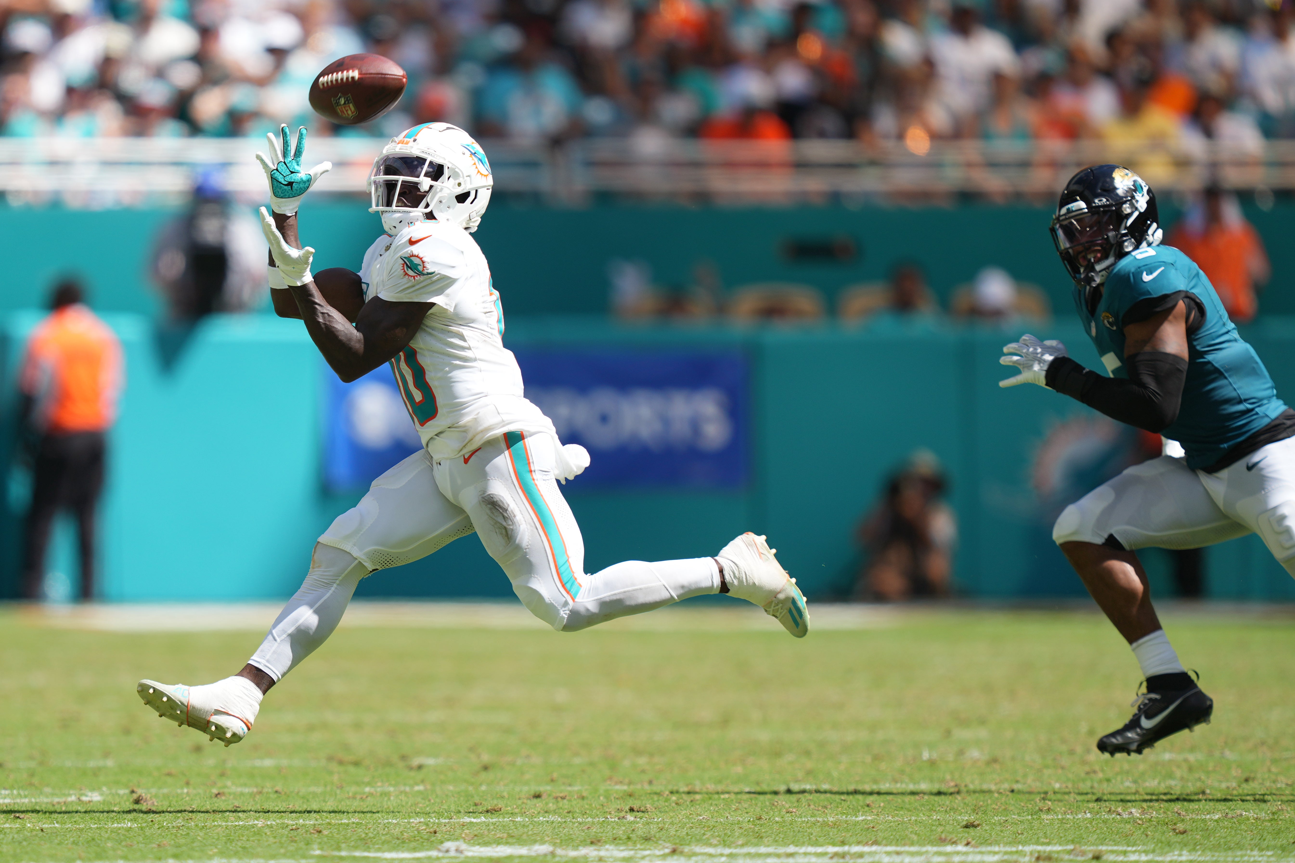 Sep 8, 2024; Miami Gardens, Florida, USA; Miami Dolphins wide receiver Tyreek Hill (10) catches a pass for an 80-yard touchdown in the third quarter as Jacksonville Jaguars safety Andre Cisco (5) follows on the play at Hard Rock Stadium.