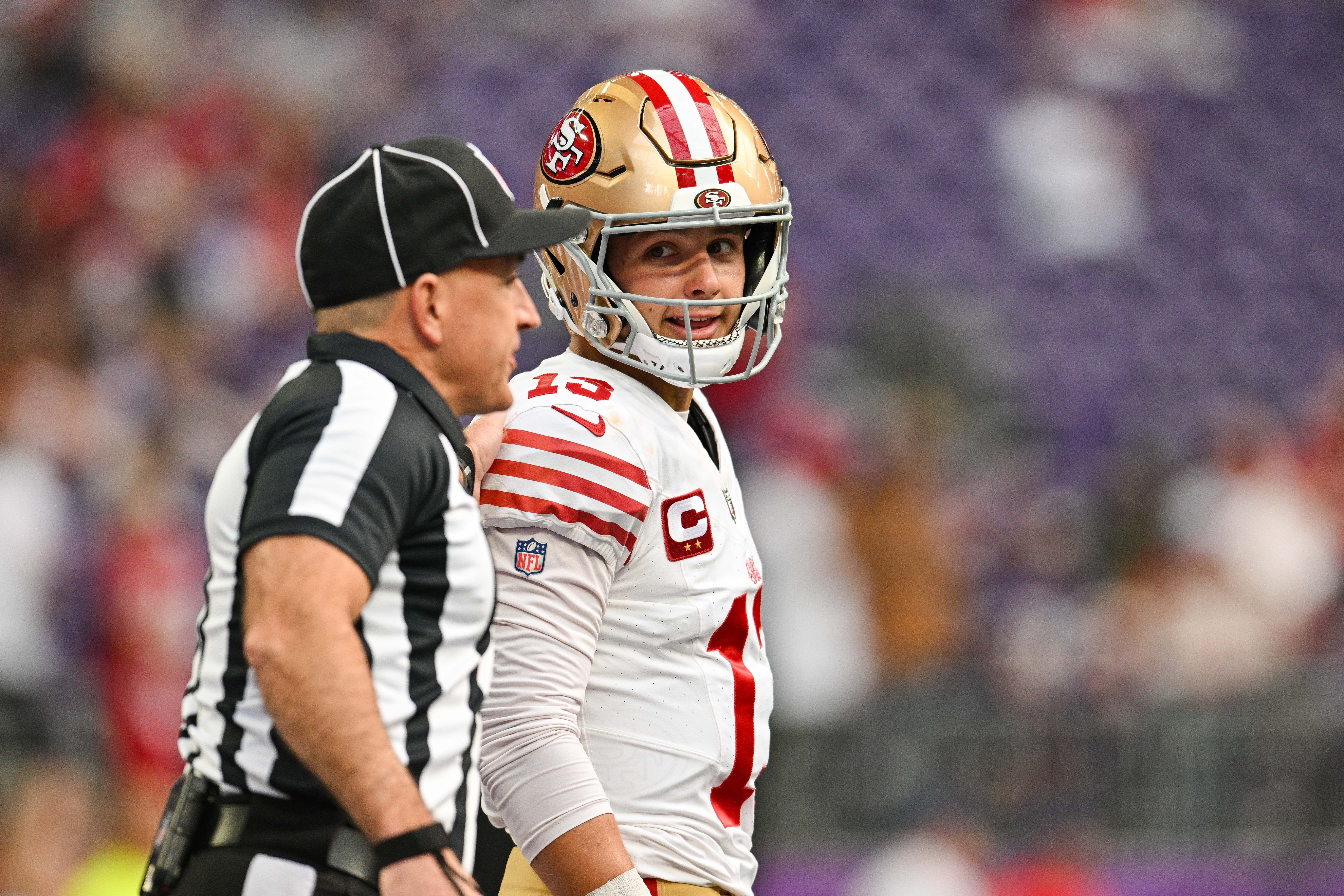 Sep 15, 2024; Minneapolis, Minnesota, USA; San Francisco 49ers quarterback Brock Purdy (13) talks with an official before the game against the Minnesota Vikings at U.S. Bank Stadium.