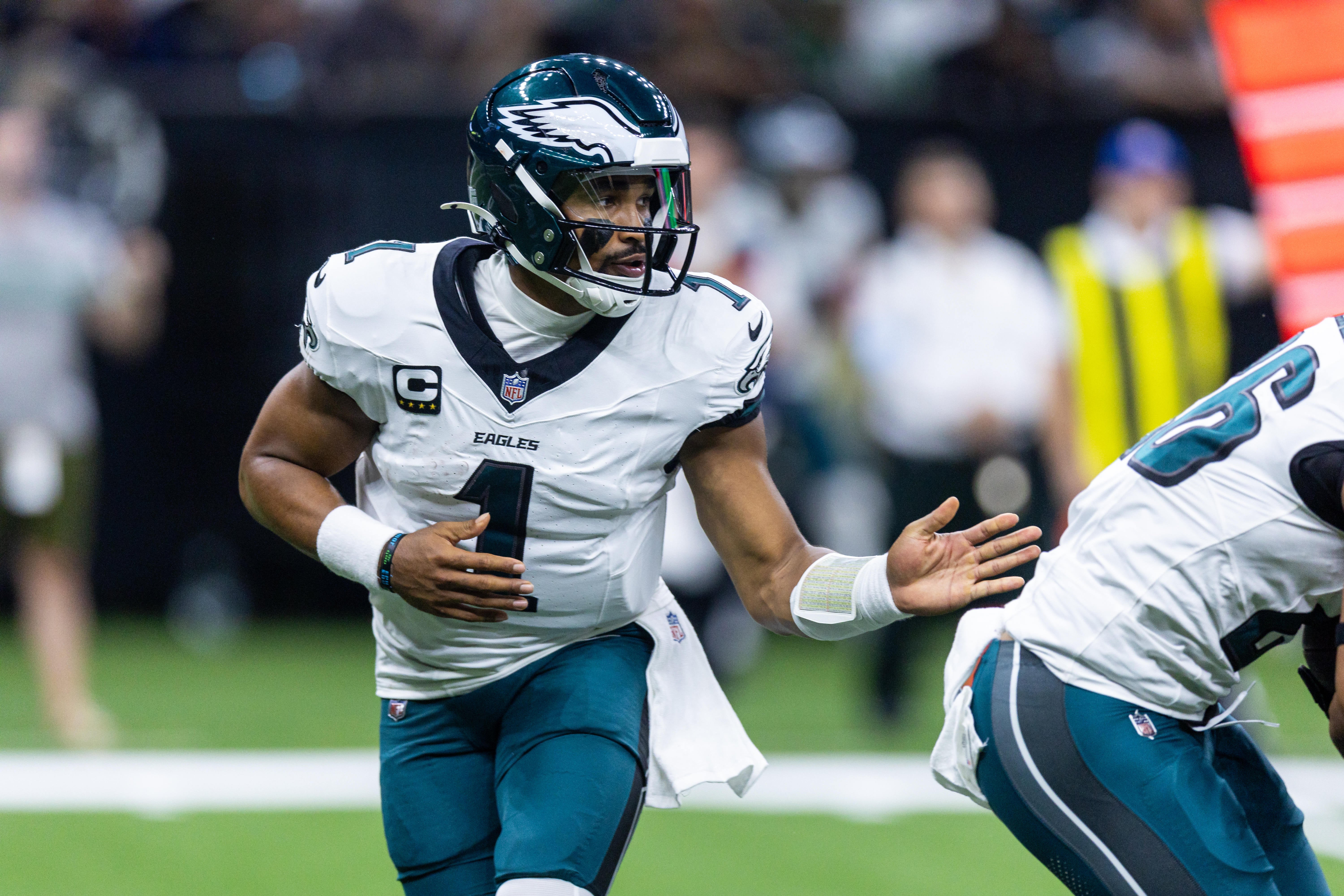 Philadelphia Eagles quarterback Jalen Hurts (1) hands off to running back Saquon Barkley (26) during the first half against the New Orleans Saints at Caesars Superdome.