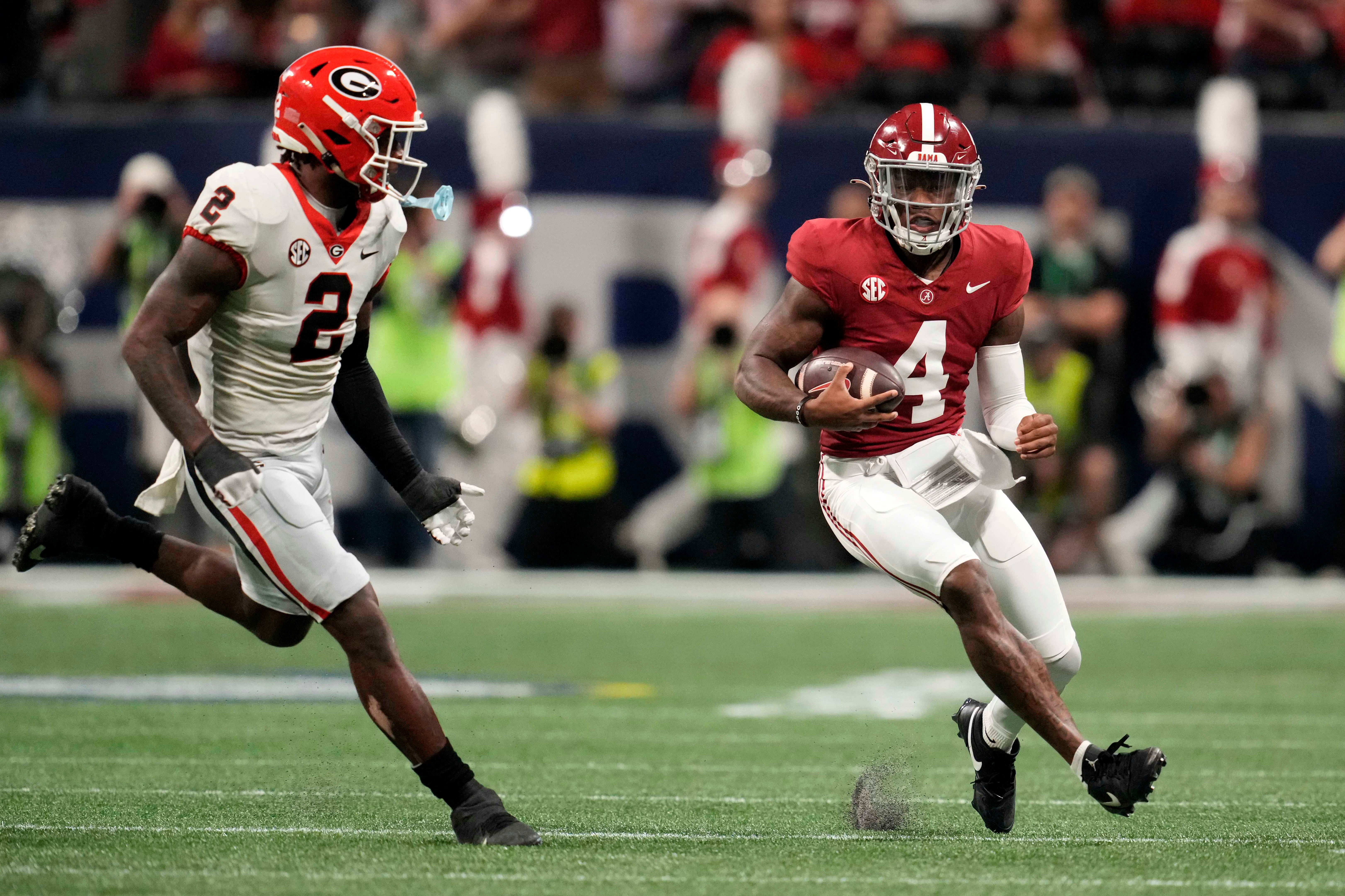 Dec 2, 2023; Atlanta, GA, USA; Alabama Crimson Tide quarterback Jalen Milroe (4) rushes the ball against Georgia Bulldogs linebacker Smael Mondon Jr. (2) during the first half in the SEC Championship game at Mercedes-Benz Stadium.
