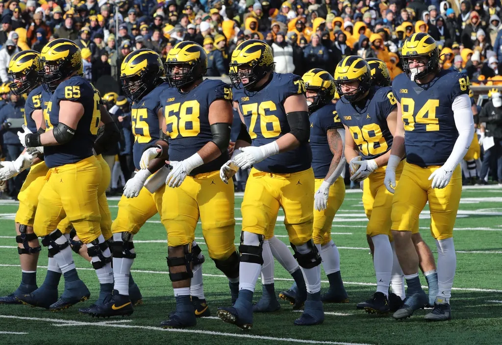 The Michigan Wolverines offensive line, including Zak Zinter (65), Olusegun Oluwatimi (55), Giovanni El-Hadi (58) and Ryan Hayes (76), and tight ends Matthew Hibner (88) and Joel Honigford