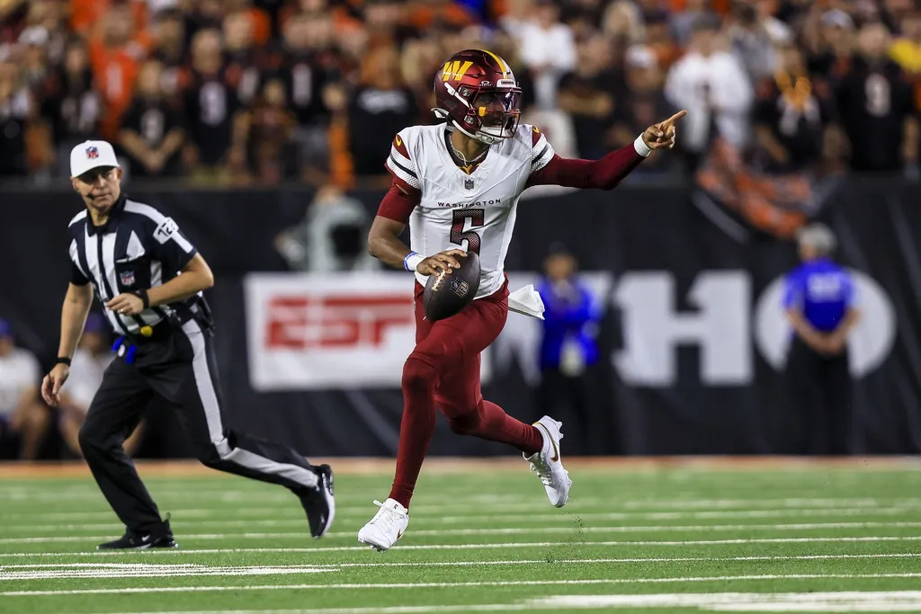 Washington Commanders quarterback Jayden Daniels (5) runs with the ball against the Cincinnati Bengals in the first half at Paycor Stadium.