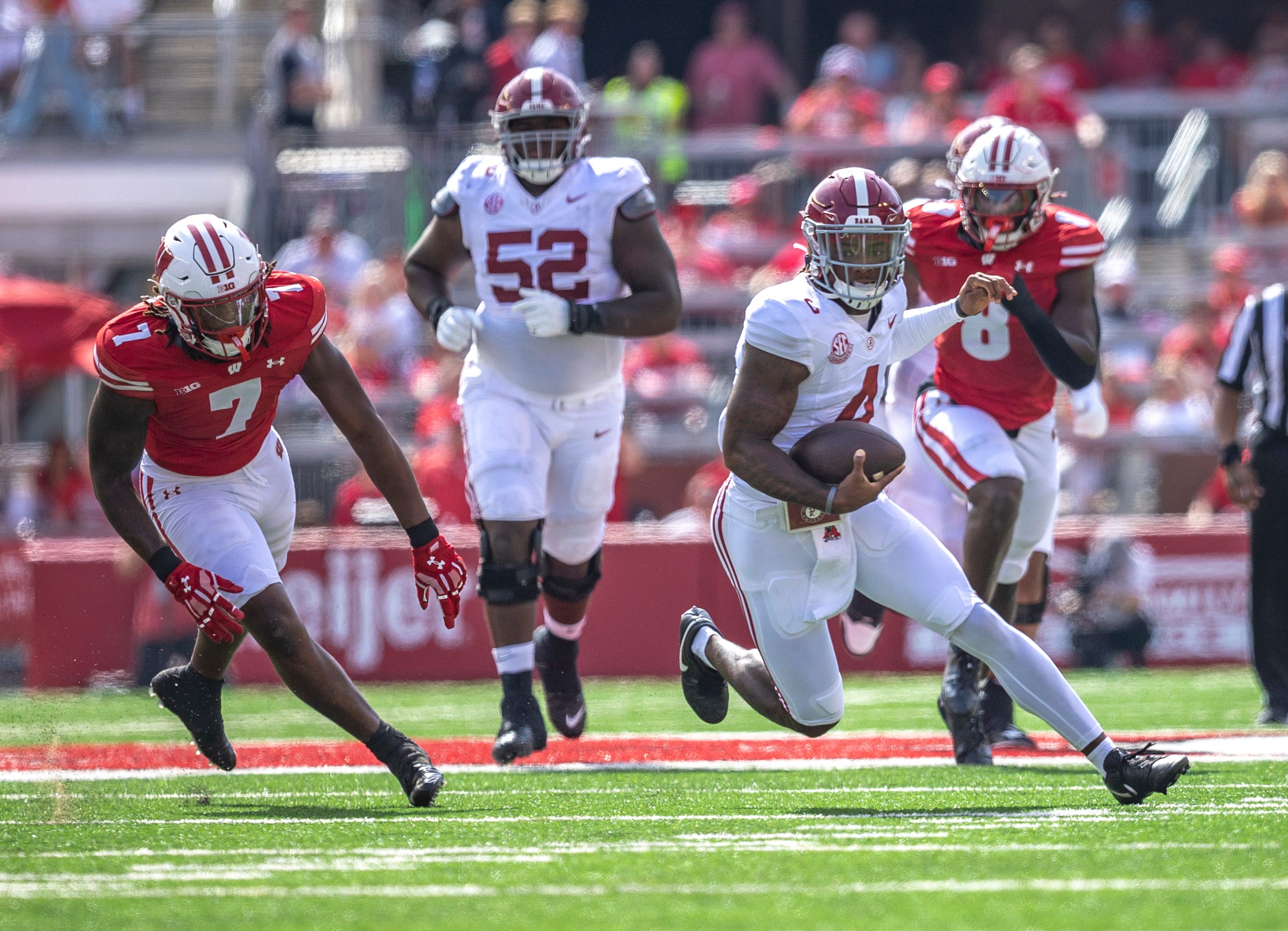 Alabama quarterback Jalen Milroe (4) runs the ball through a defense during the game against Wisconsin at Camp Randall Stadium.