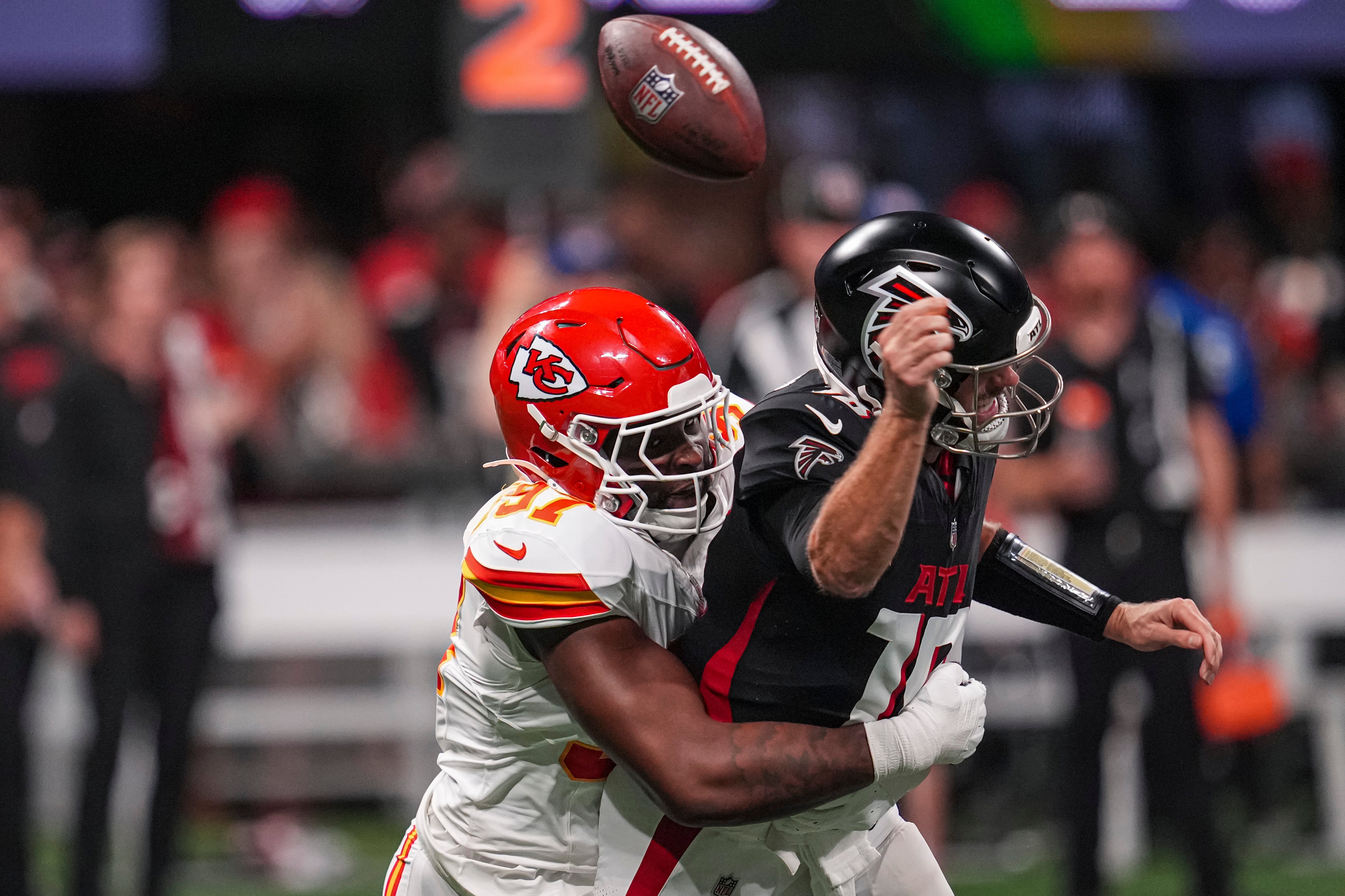 Falcons quarterback Kirk Cousins (18) is hit by Chiefs defensive end Felix Anudike-Uzomah (97) and fumbles the ball during the first half at Mercedes-Benz Stadium.