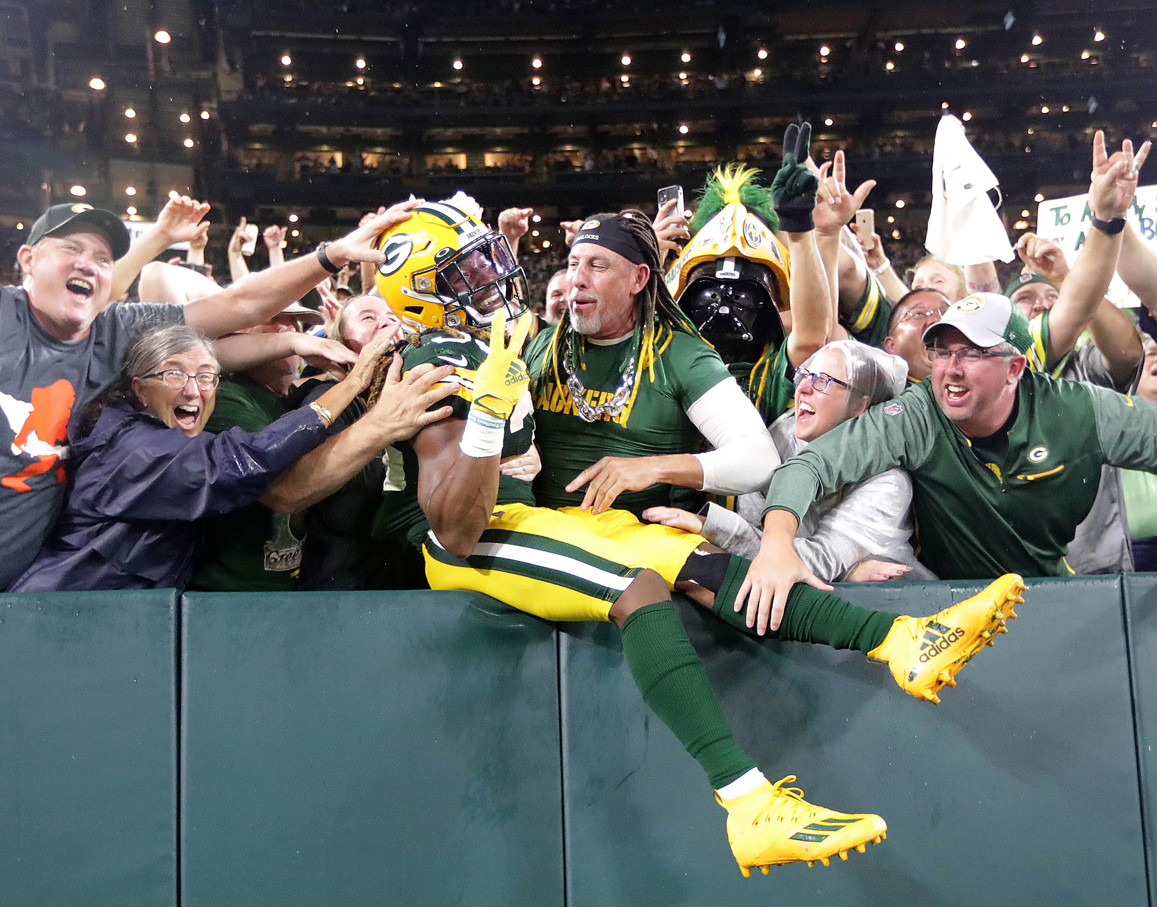 Sep 20, 2021; Green Bay, WIsconsin, USA; Green Bay Packers running back Aaron Jones (33) celebrates with a Lambeau Leap after scoring a touchdown against the Detroit Lions during third quarter at Lambeau Field.