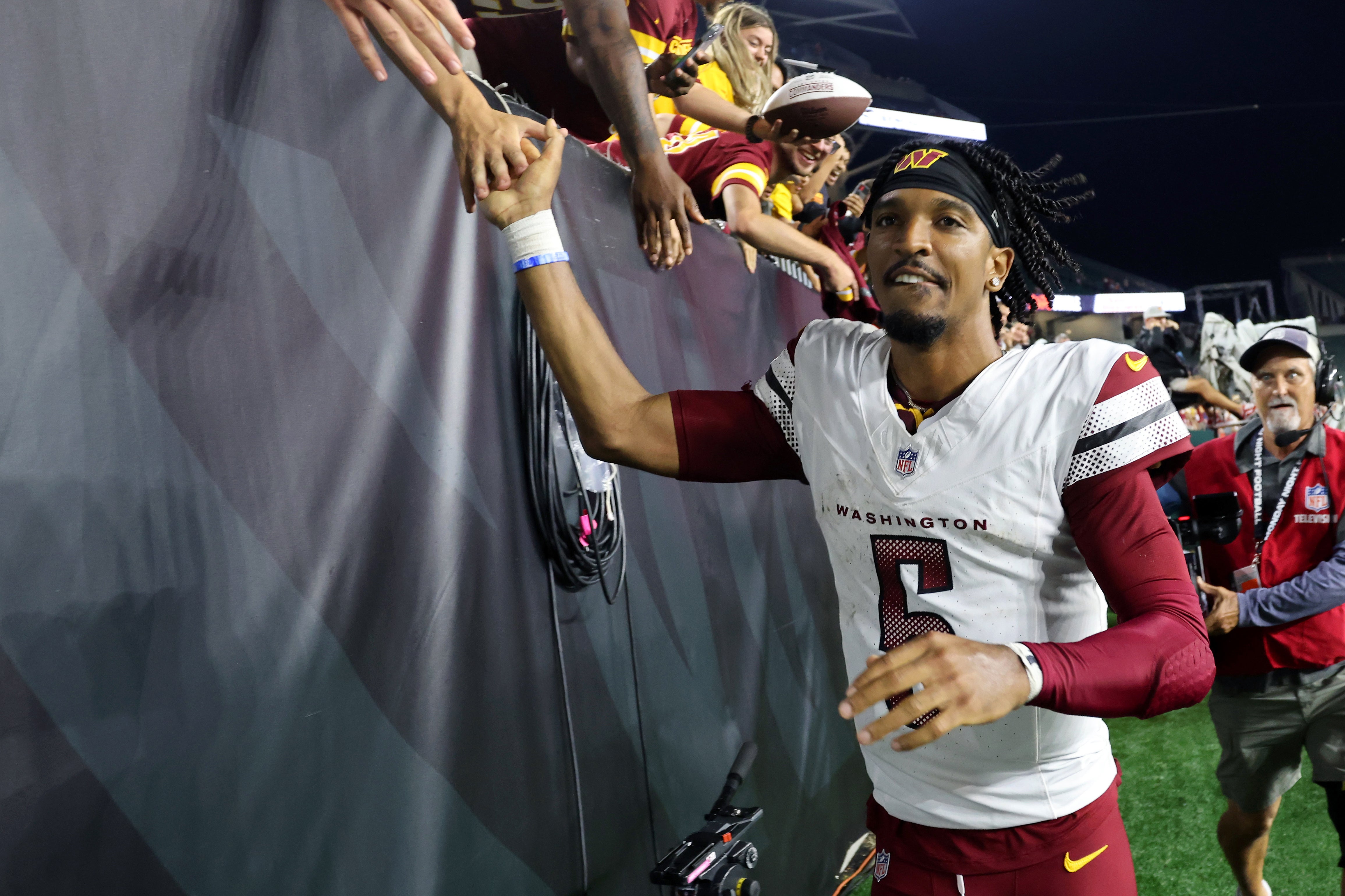 Sep 23, 2024; Cincinnati, Ohio, USA; Washington Commanders quarterback Jayden Daniels (5) celebrates with fans following the win against the Cincinnati Bengals at Paycor Stadium.