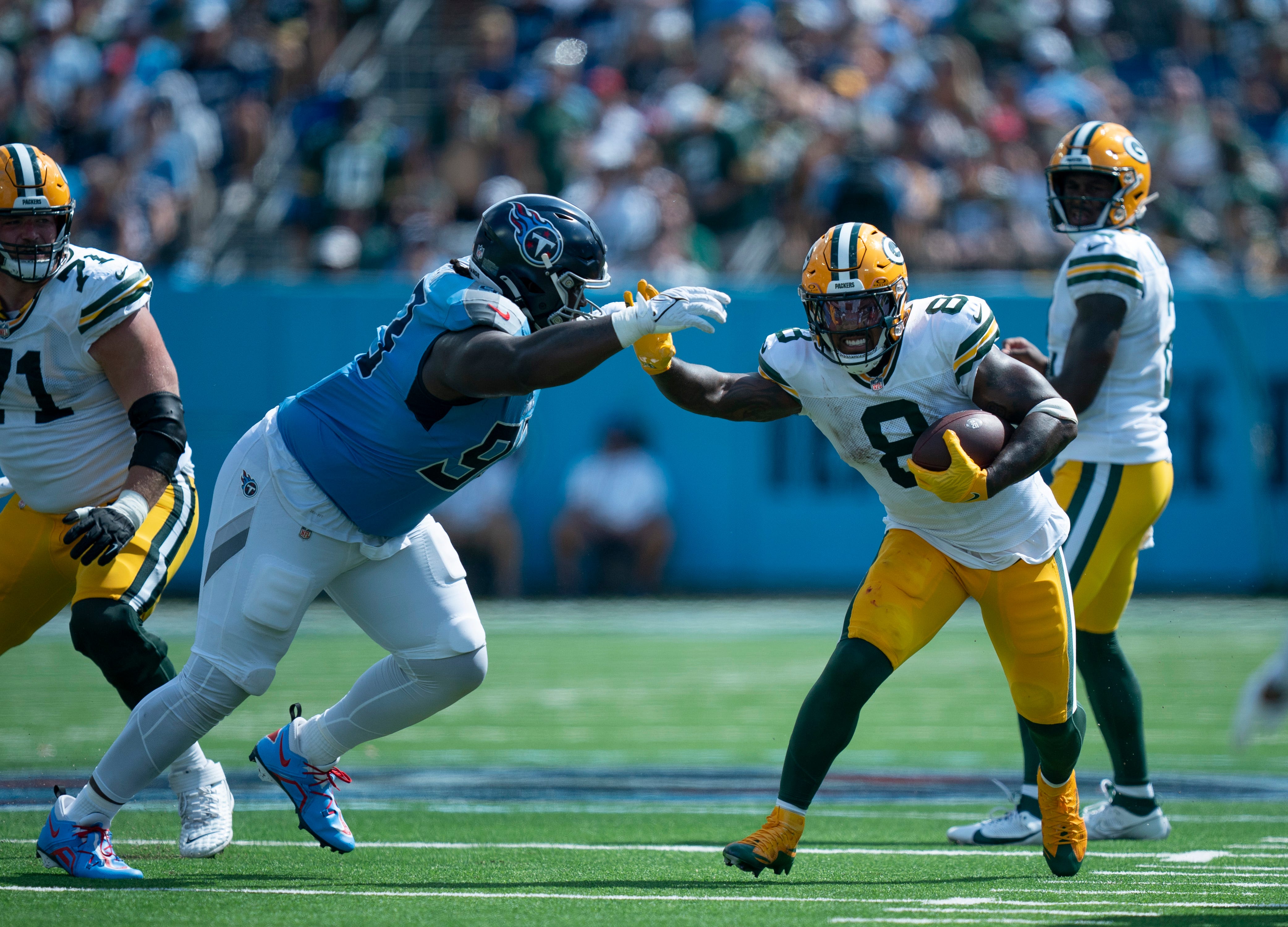 Tennessee Titans defensive tackle T'Vondre Sweat (93) tackles Green Bay Packers running back Josh Jacobs (8) during their game at Nissan Stadium in Nashville, Tenn., Sunday, Sept. 22, 2024.