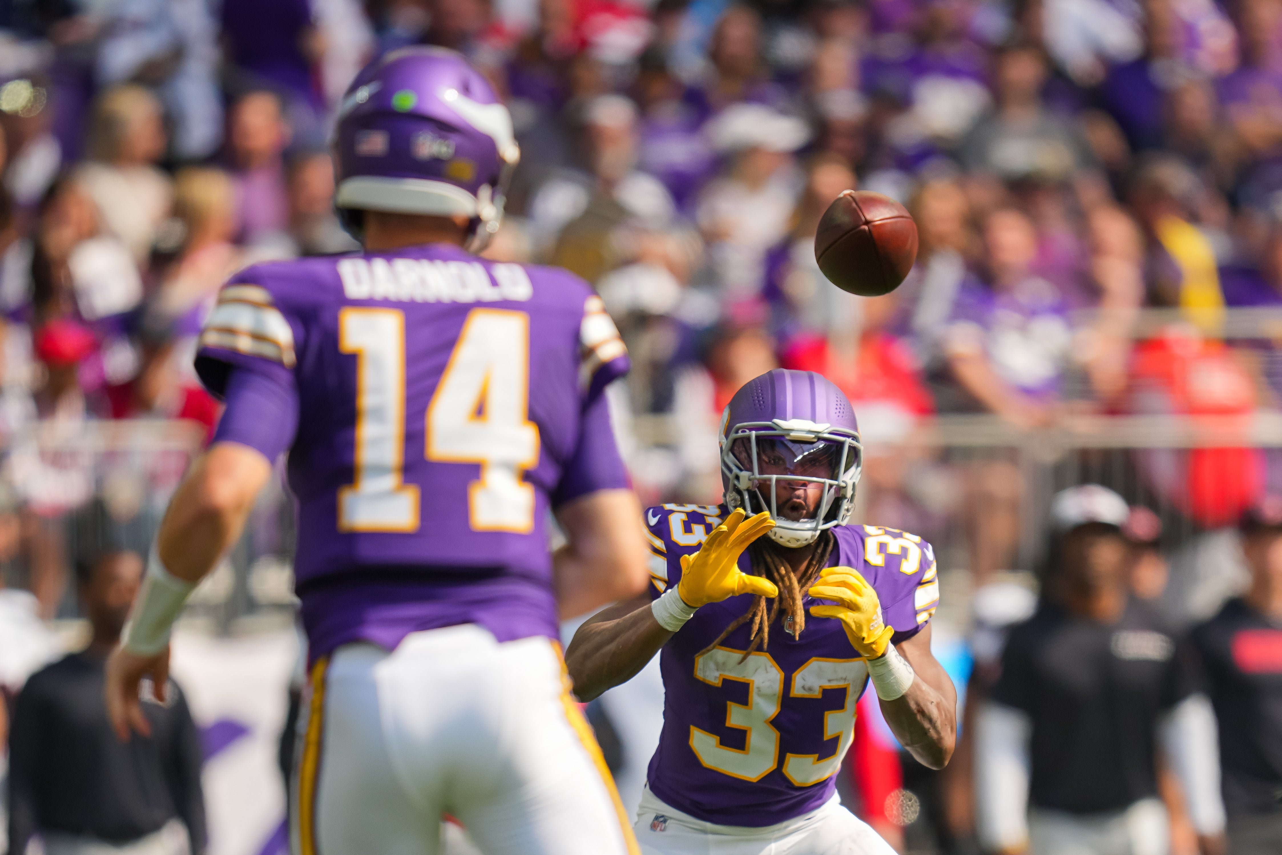 Minnesota Vikings running back Aaron Jones (33) catches a pass from quarterback Sam Darnold (14) against the Houston Texans in the second quarter at U.S. Bank Stadium