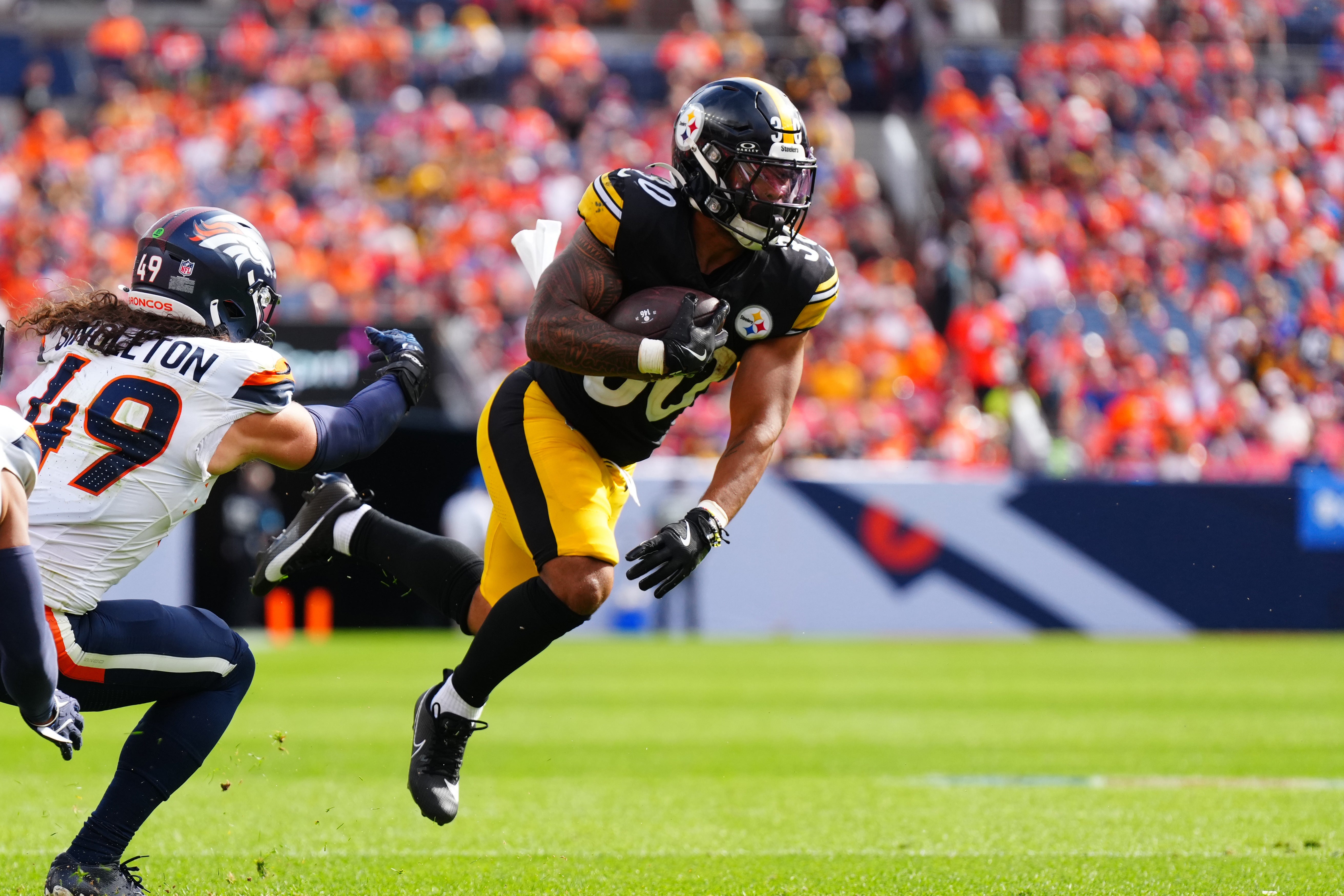 Sep 15, 2024; Denver, Colorado, USA; Pittsburgh Steelers running back Jaylen Warren (30) catches the ball past Denver Broncos linebacker Alex Singleton (49) in the second quarter at Empower Field at Mile High.
