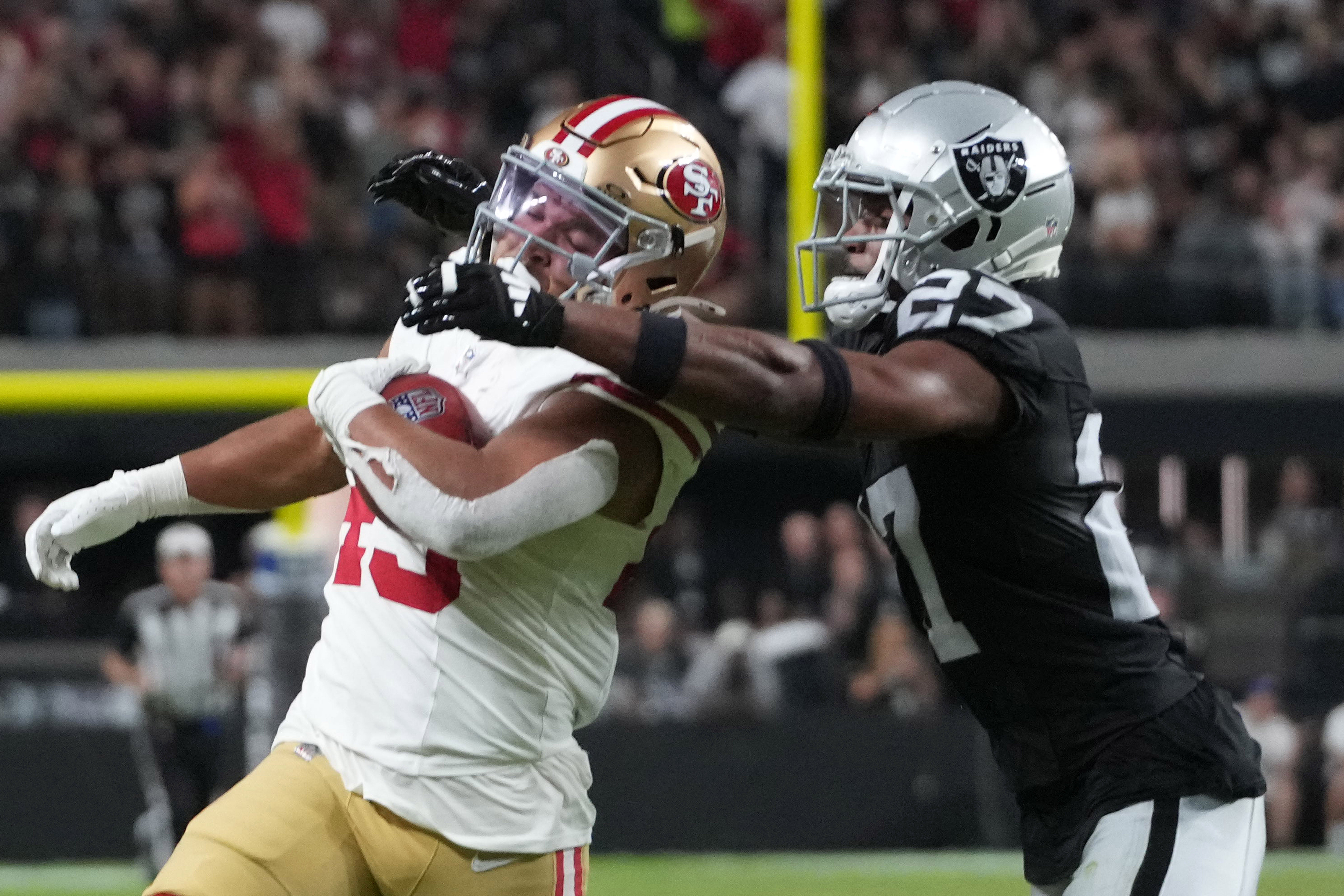 San Francisco 49ers running back Isaac Guerendo (49) is tackled by Las Vegas Raiders cornerback Sam Webb (27) on kickoff return against the Las Vegas Raiders in the first half at Allegiant Stadium.