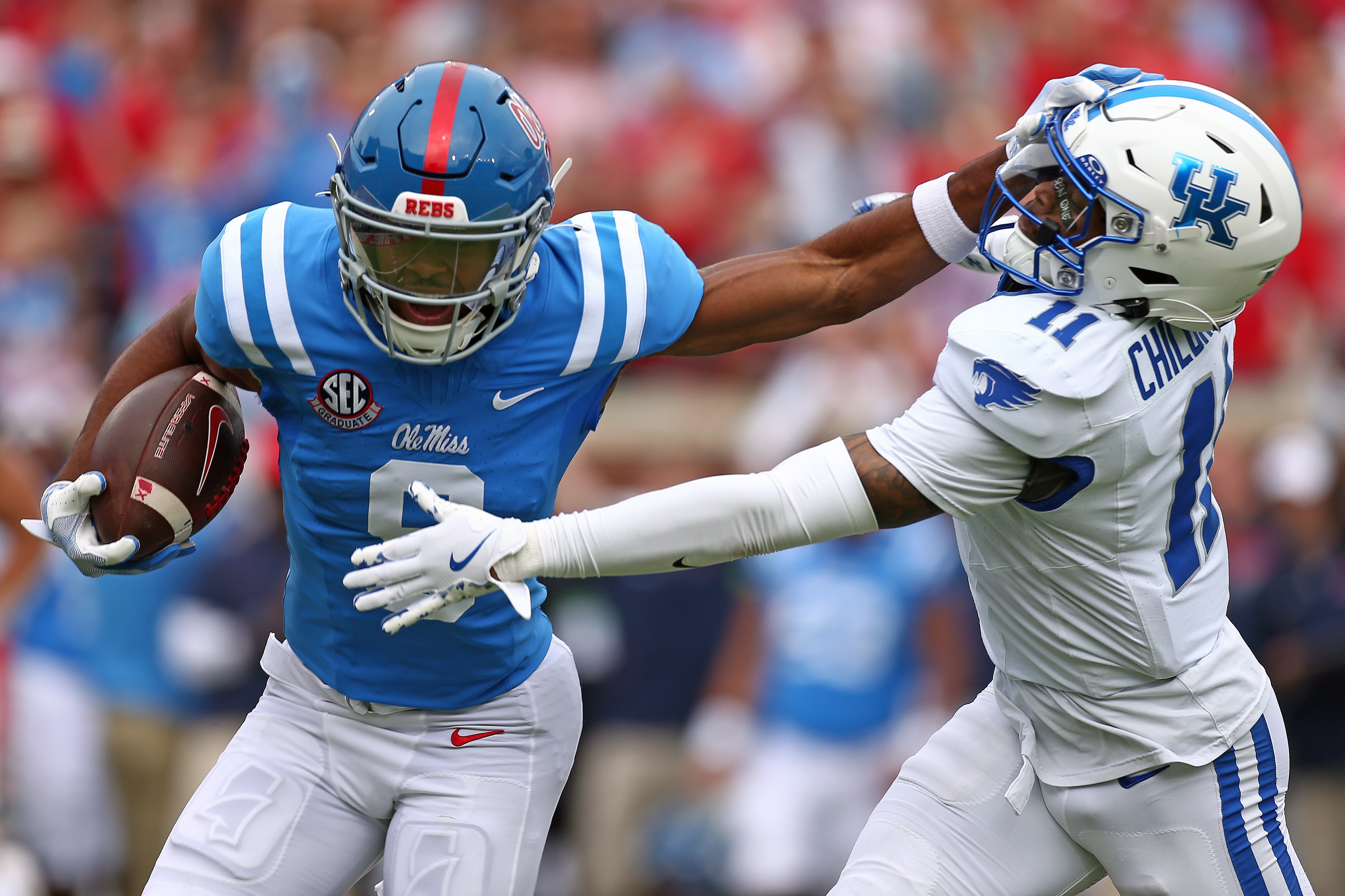 Sep 28, 2024; Oxford, Mississippi, USA; Mississippi Rebels wide receiver Tre Harris (9) stiff arms Kentucky Wildcats defensive back Zion Childress (11) after a catch during the first half at Vaught-Hemingway Stadium.