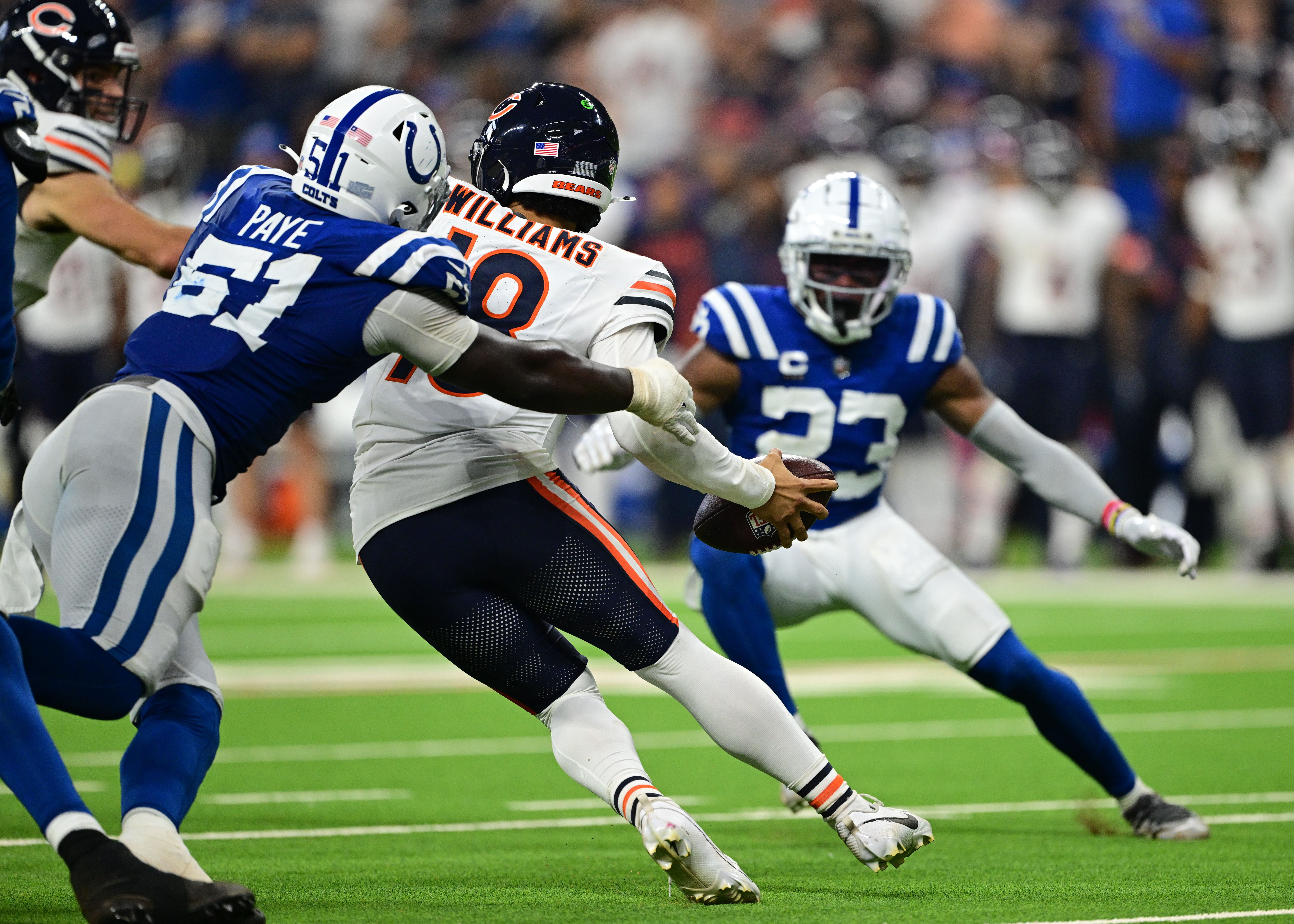 Sep 22, 2024; Indianapolis, Indiana, USA; Chicago Bears quarterback Caleb Williams (18) attempts to get away from Indianapolis Colts defensive end Kwity Paye (51) during the second half at Lucas Oil Stadium.
