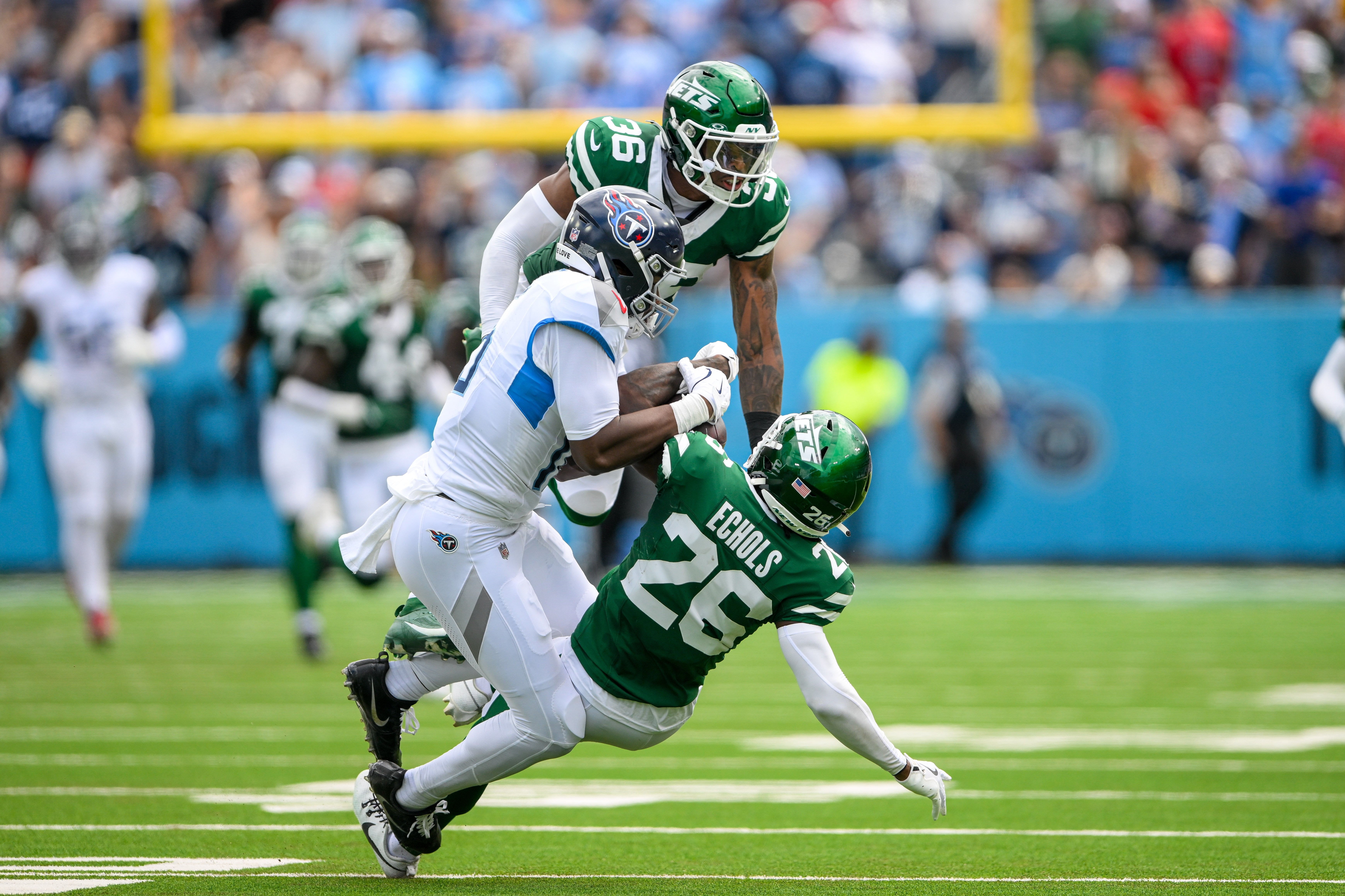 New York Jets cornerback Brandin Echols (26) intercepts the pass thrown to Tennessee Titans wide receiver Treylon Burks (16) during the first half at Nissan Stadium. Steve Roberts-Imagn Images