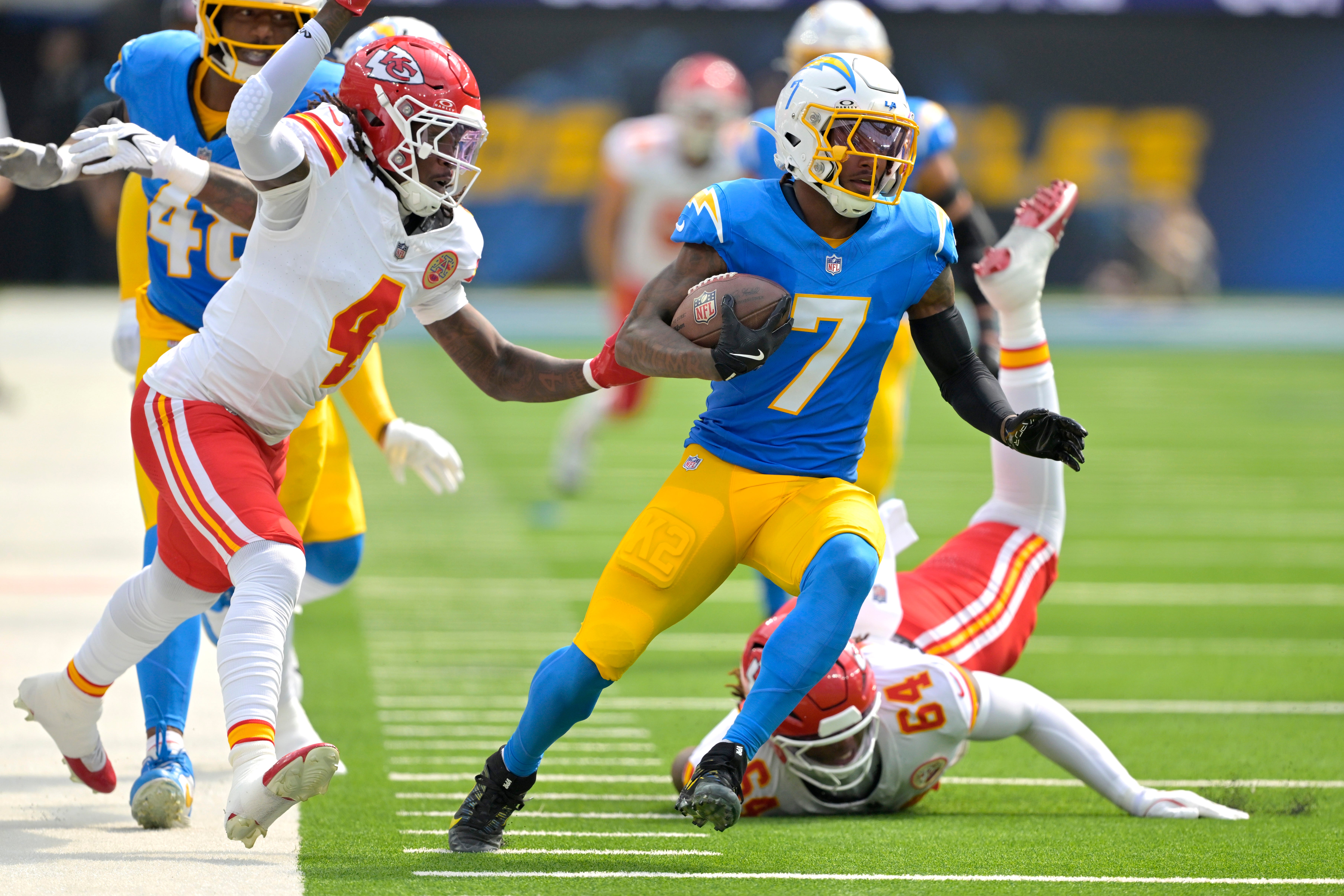 Sep 29, 2024; Inglewood, California, USA; Los Angeles Chargers cornerback Kristian Fulton (7) avoids a tackle by Kansas City Chiefs offensive tackle Wanya Morris (64) after an interception in the first half at SoFi Stadium.