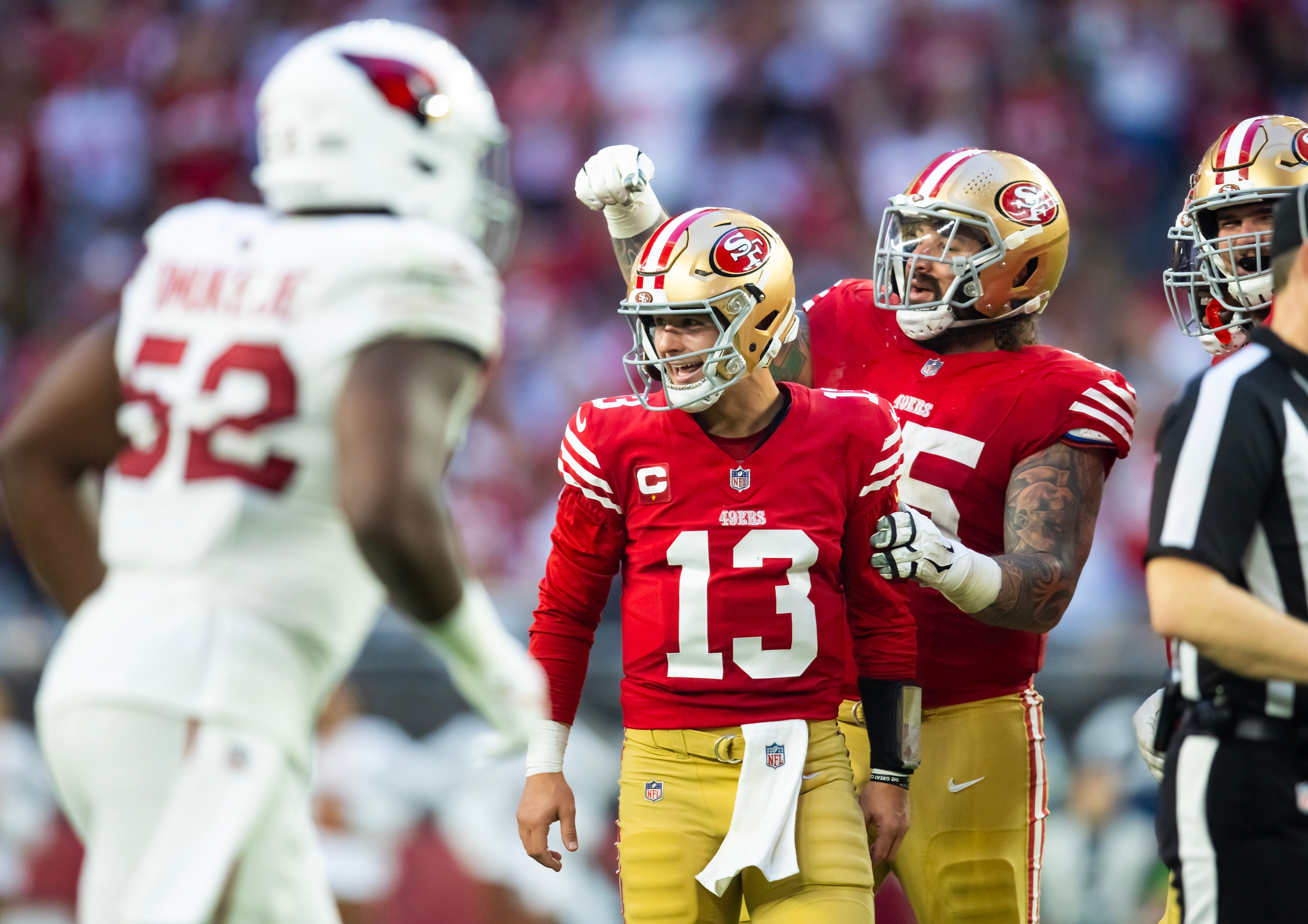 San Francisco 49ers quarterback Brock Purdy (13) celebrates a touchdown with guard Jon Feliciano (55) against the Arizona Cardinals at State Farm Stadium.