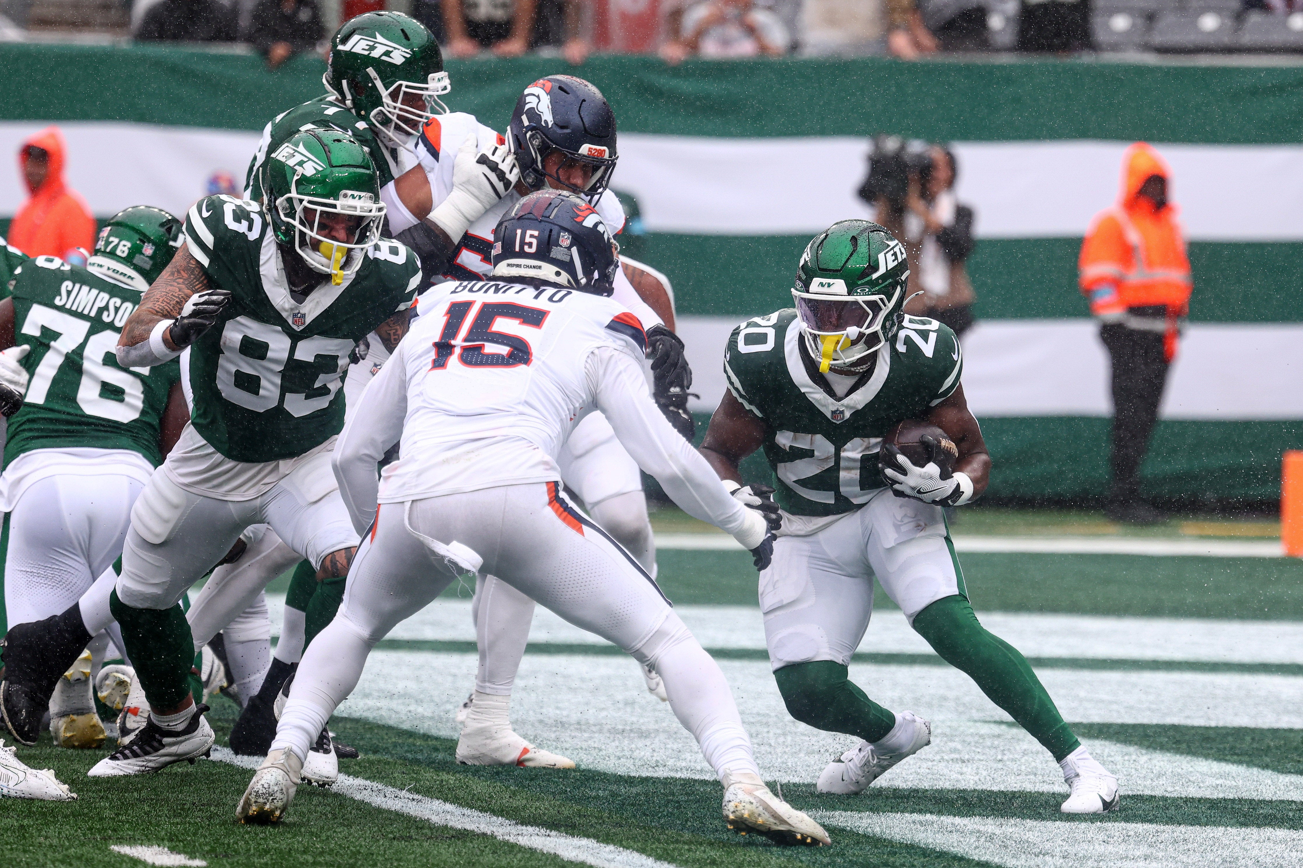 ew York Jets running back Breece Hall (20) carries the ball as Denver Broncos linebacker Nik Bonitto (15) defends during the first half at MetLife Stadium.