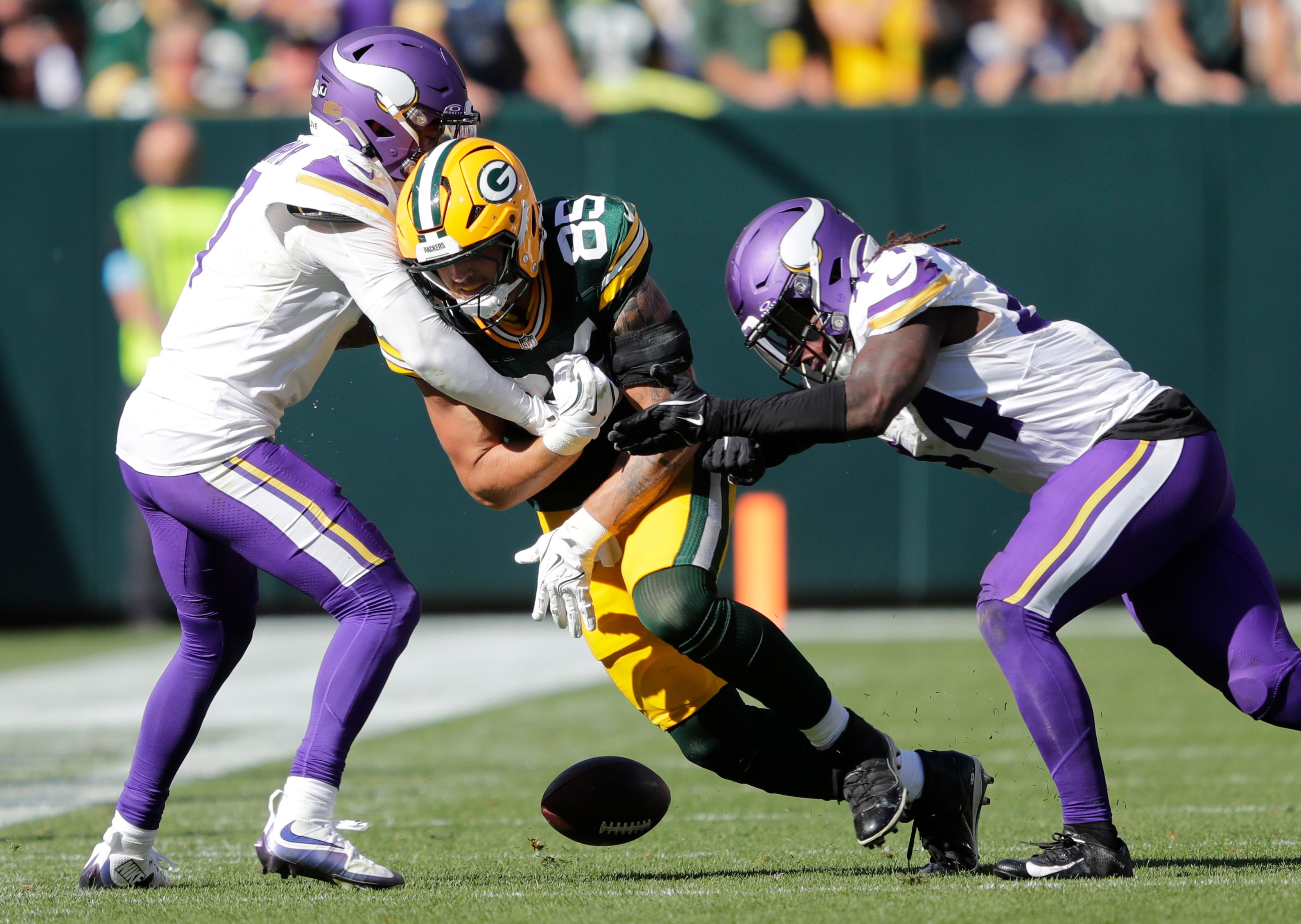 Green Bay Packers tight end Tucker Kraft (85) fumbles the ball against Minnesota Vikings cornerback Byron Murphy Jr. (7) and Josh Metellus (44) in the fourth quarter during their football game Sunday, September 29, 2024, at Lambeau Field in Green Bay, Wisconsin.