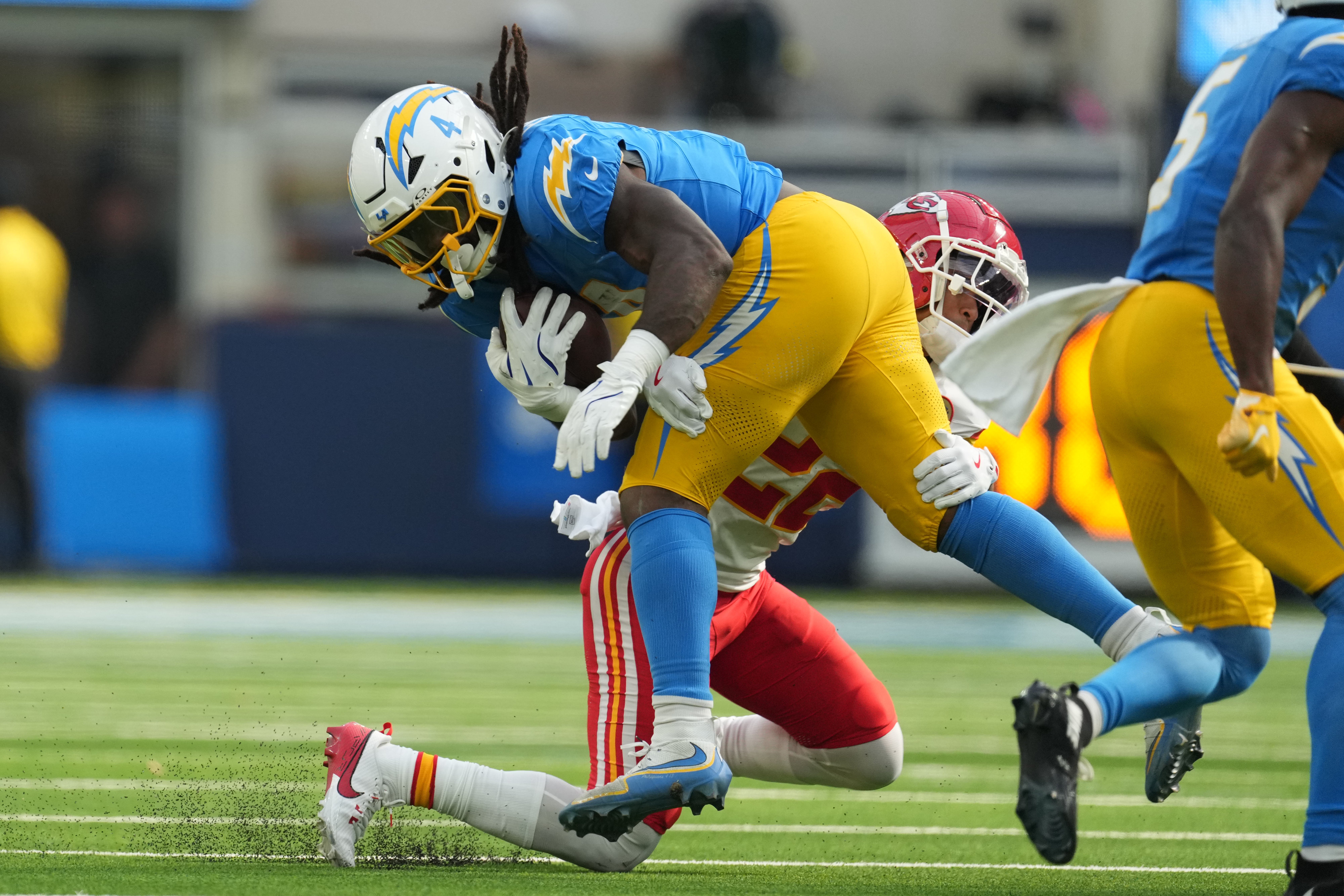 Chargers running back Gus Edwards is tackled by Chiefs linebacker Drue Tranquill.
