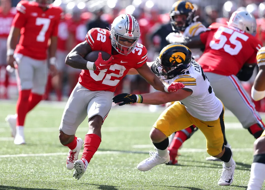 Ohio State Buckeyes running back TreVeyon Henderson (32) runs as he is tackled by Iowa Hawkeyes linebacker Jayden Montgomery (36) during the third quarter at Ohio Stadium. 