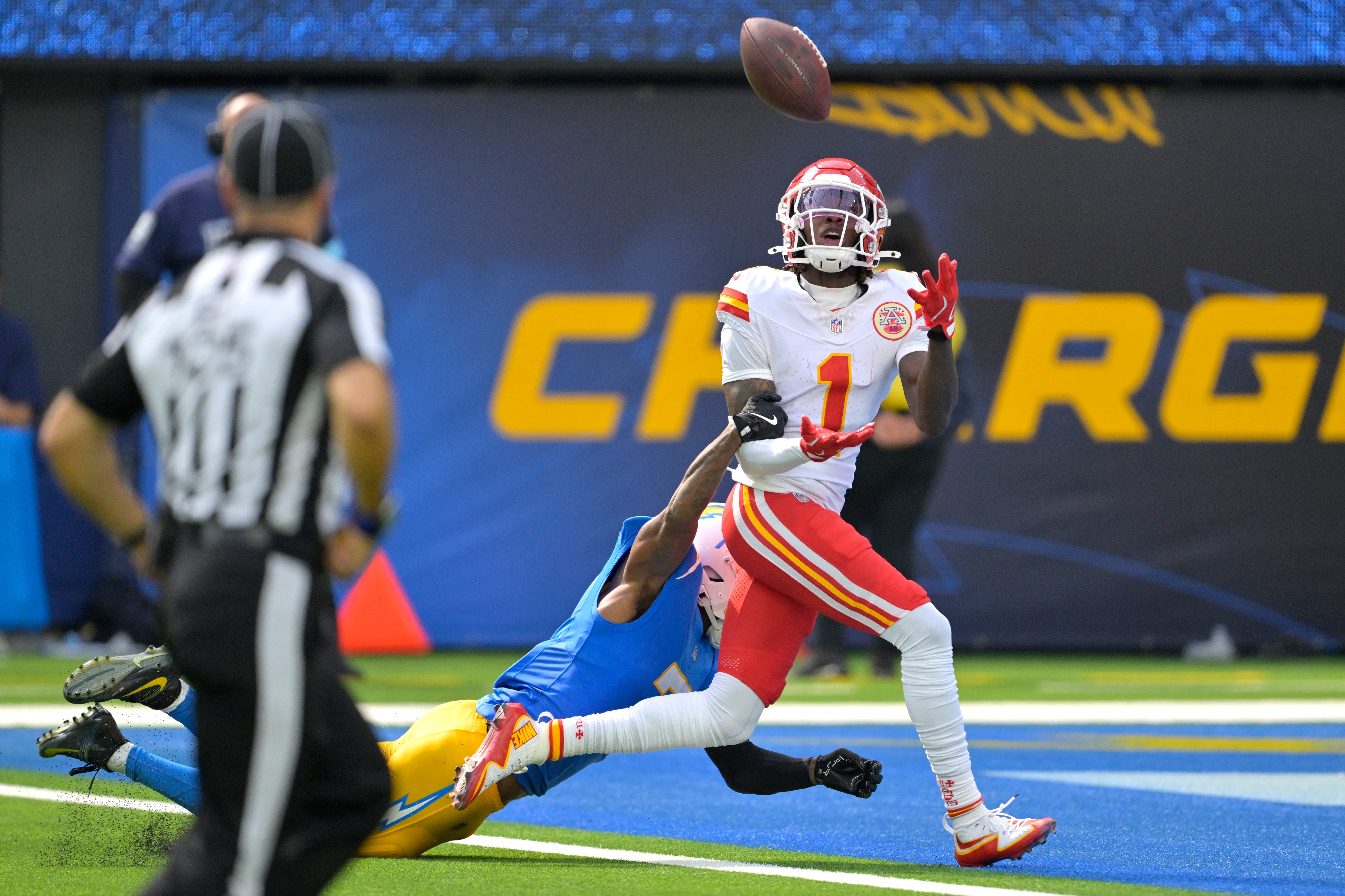 Sep 29, 2024; Inglewood, California, USA; Kansas City Chiefs wide receiver Xavier Worthy (1) is defended by Los Angeles Chargers cornerback Kristian Fulton (7) as he hangs on to a touchdown pass in the first half at SoFi Stadium.