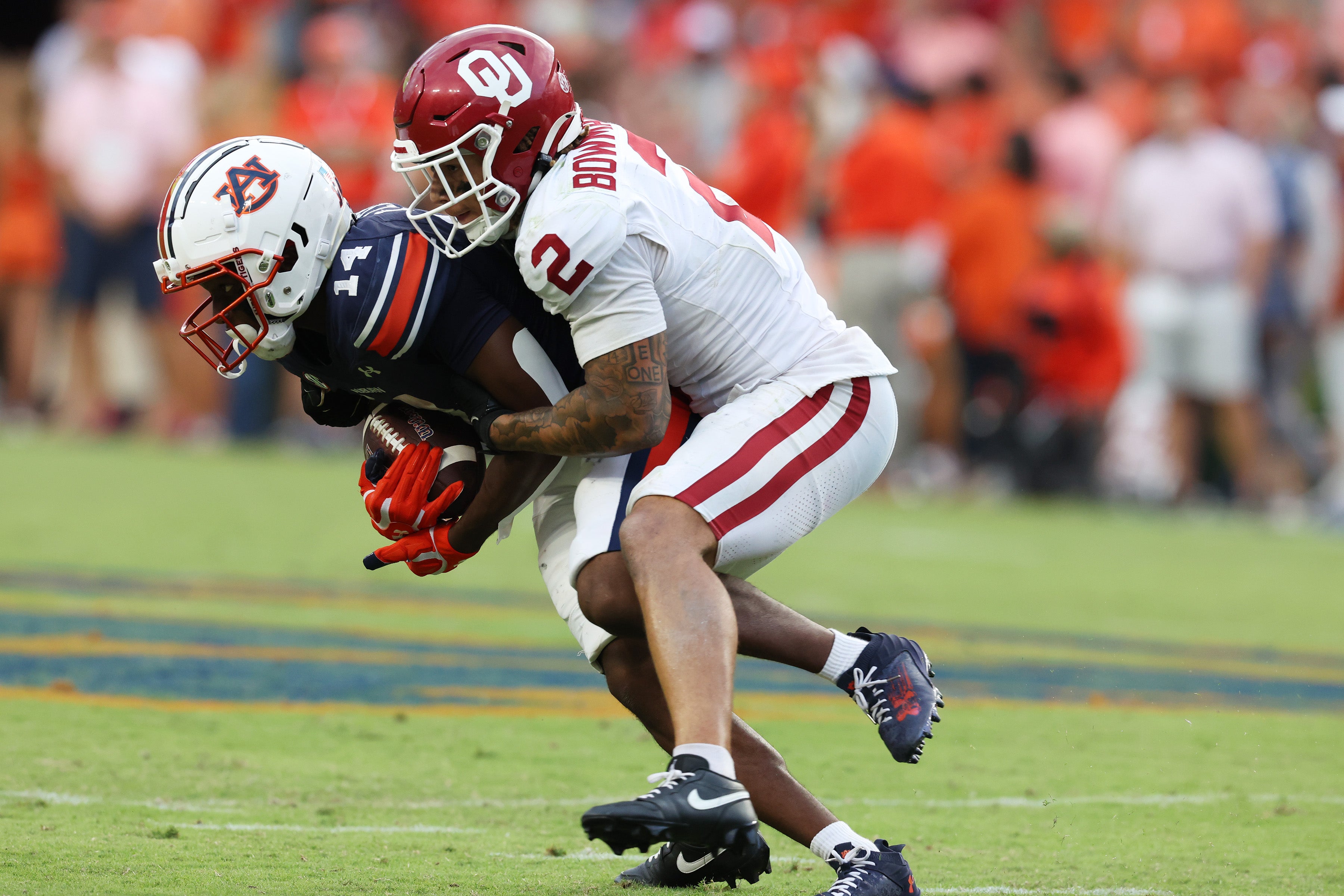 Caption: Sep 28, 2024; Auburn, Alabama, USA; Oklahoma Sooners defensive back Billy Bowman Jr. (2) tackles Auburn Tigers wide receiver Robert Lewis (14) during the fourth quarter at Jordan-Hare Stadium.
