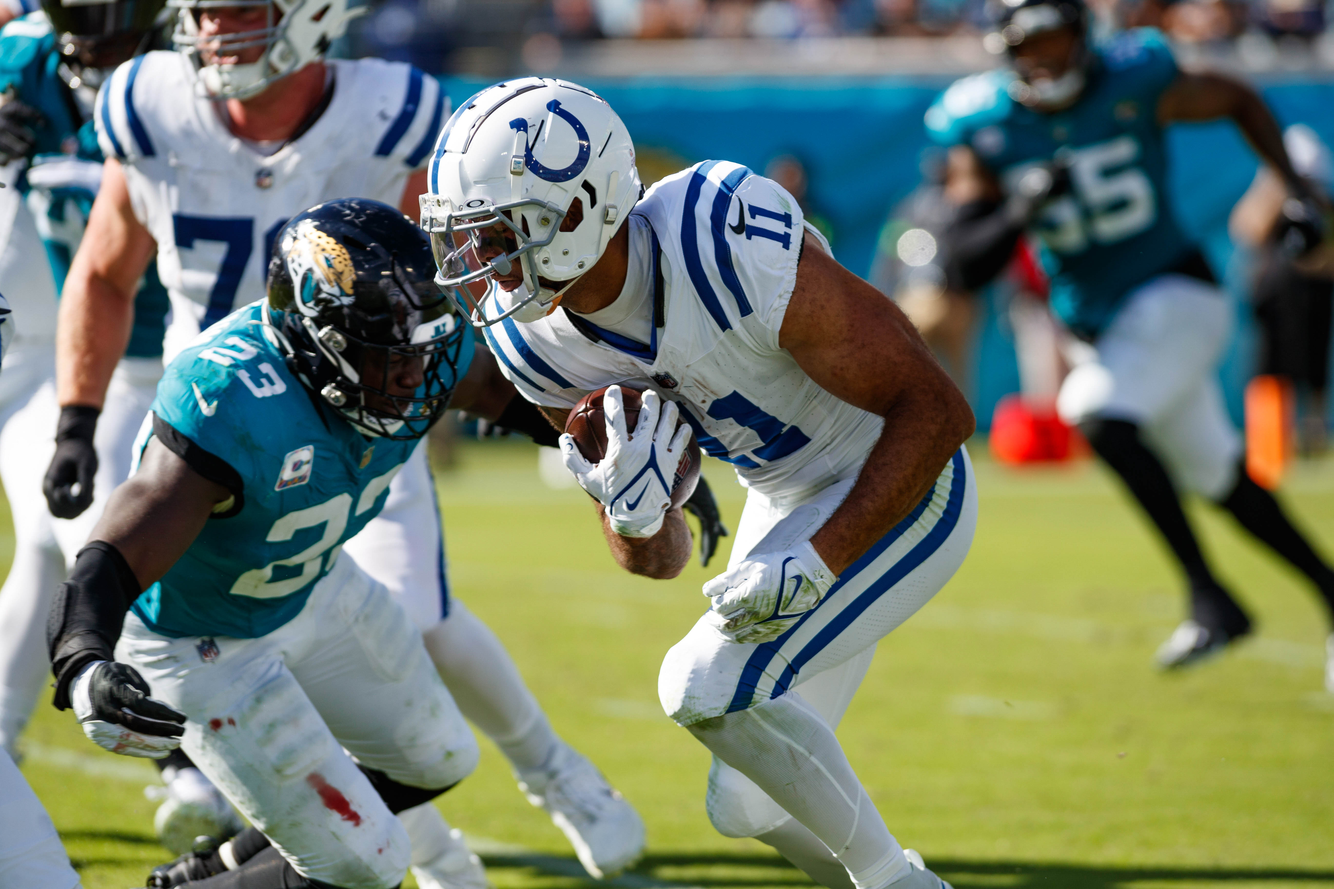 Oct 15, 2023; Jacksonville, Florida, USA; Indianapolis Colts wide receiver Michael Pittman Jr. (11) runs with the ball past Jacksonville Jaguars linebacker Foyesade Oluokun (23) during the fourth quarter at EverBank Stadium.