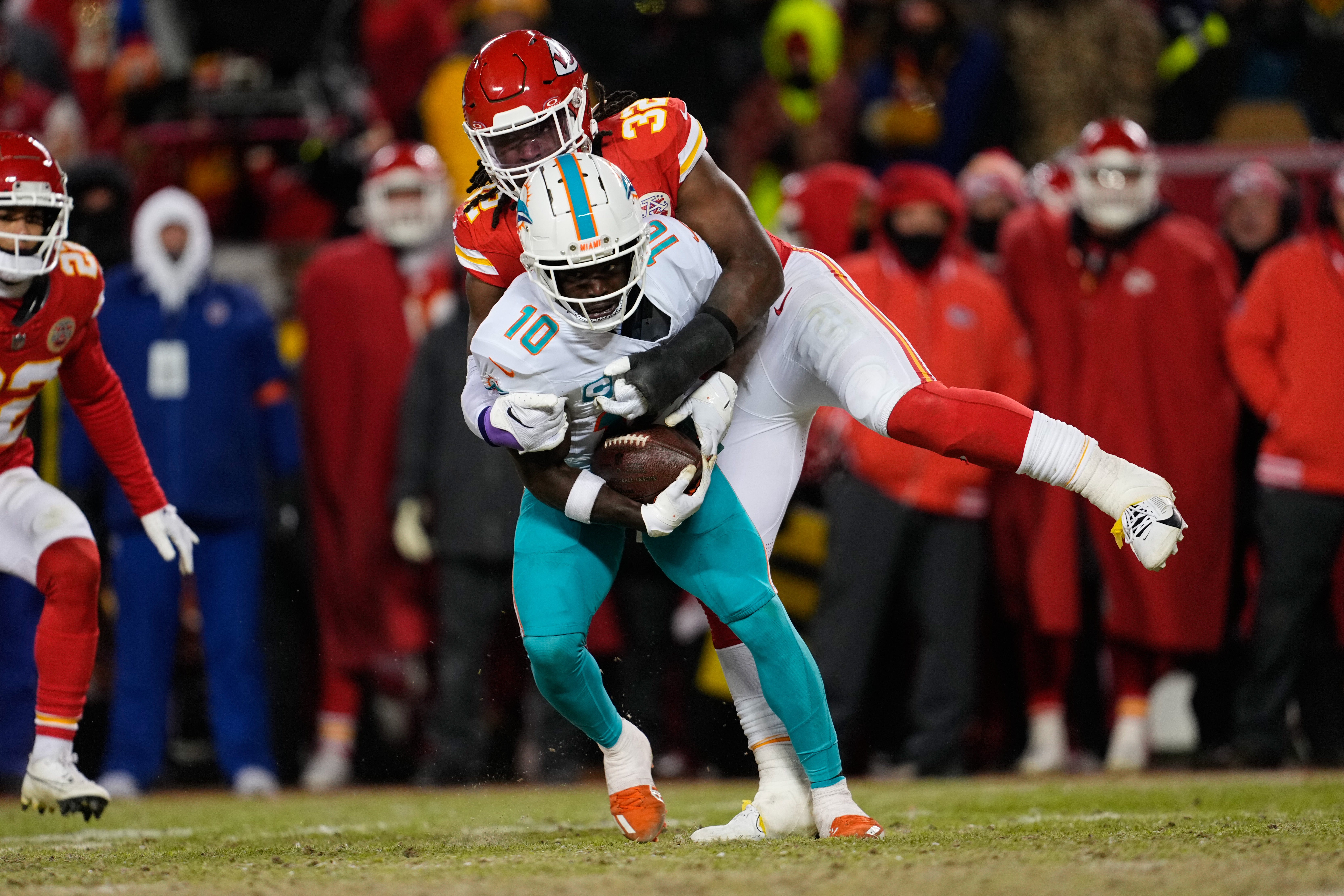 Jan 13, 2024; Kansas City, Missouri, USA; Miami Dolphins wide receiver Tyreek Hill (10) is brought down by Kansas City Chiefs linebacker Nick Bolton (32) during the second half of the 2024 AFC wild card game at GEHA Field at Arrowhead Stadium.