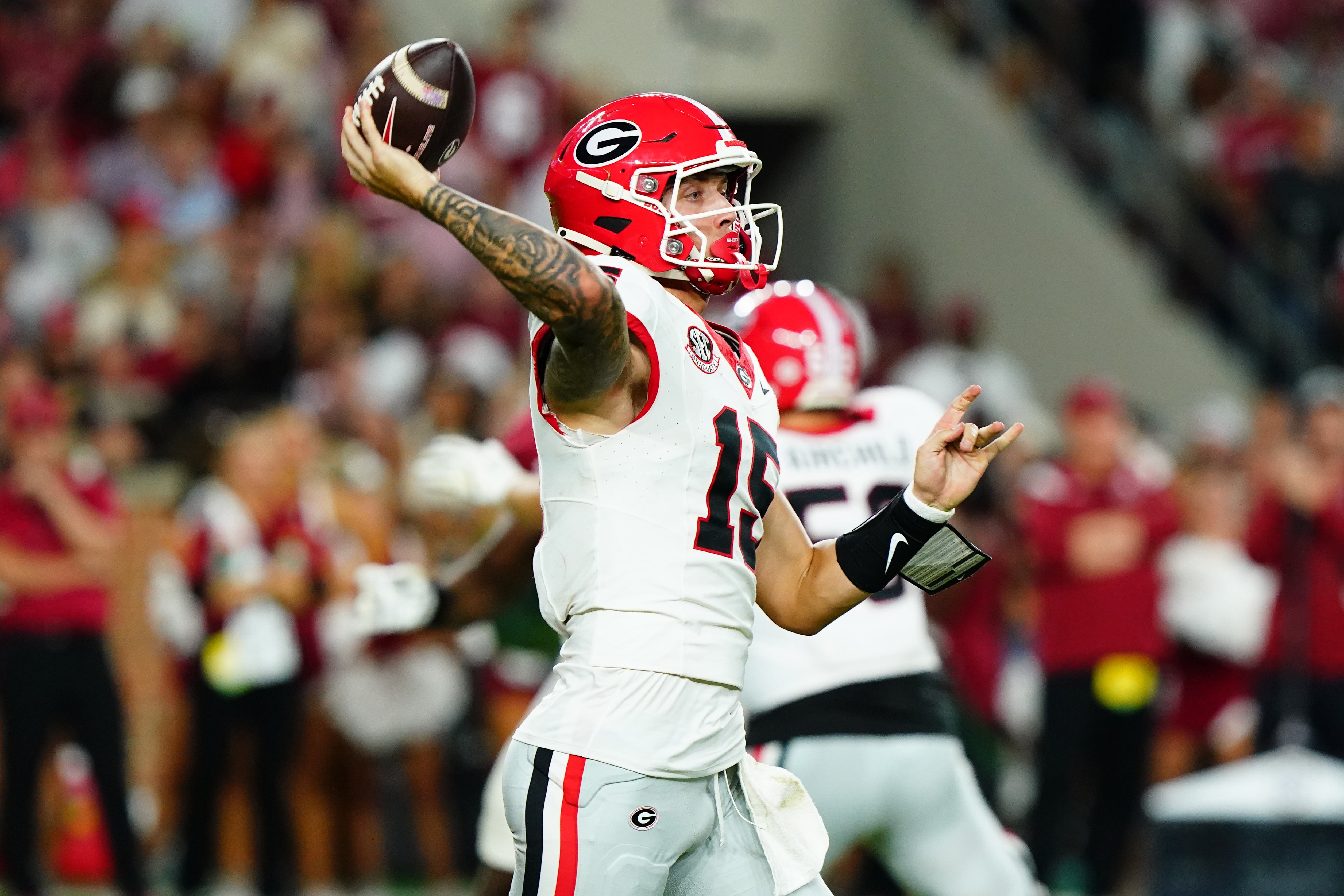 Georgia Bulldogs quarterback Carson Beck (15) rolls out to throw against the Alabama Crimson Tide during the third quarter at Bryant-Denny Stadium.