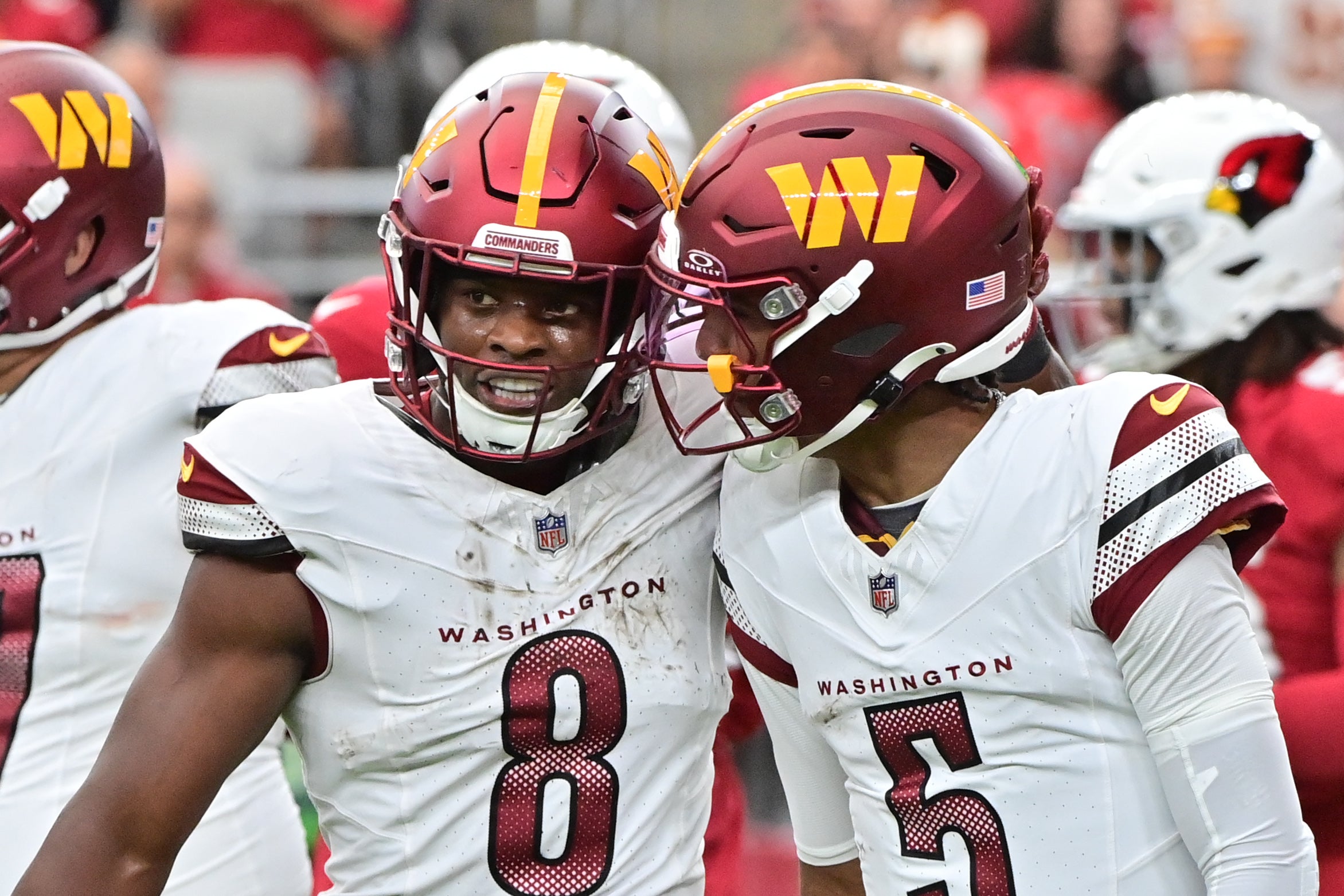 Sep 29, 2024; Glendale, Arizona, USA; Washington Commanders running back Brian Robinson Jr. (8) celebrates with quarterback Jayden Daniels (5) after scoring a touchdown in the first half against the Arizona Cardinals at State Farm Stadium.
