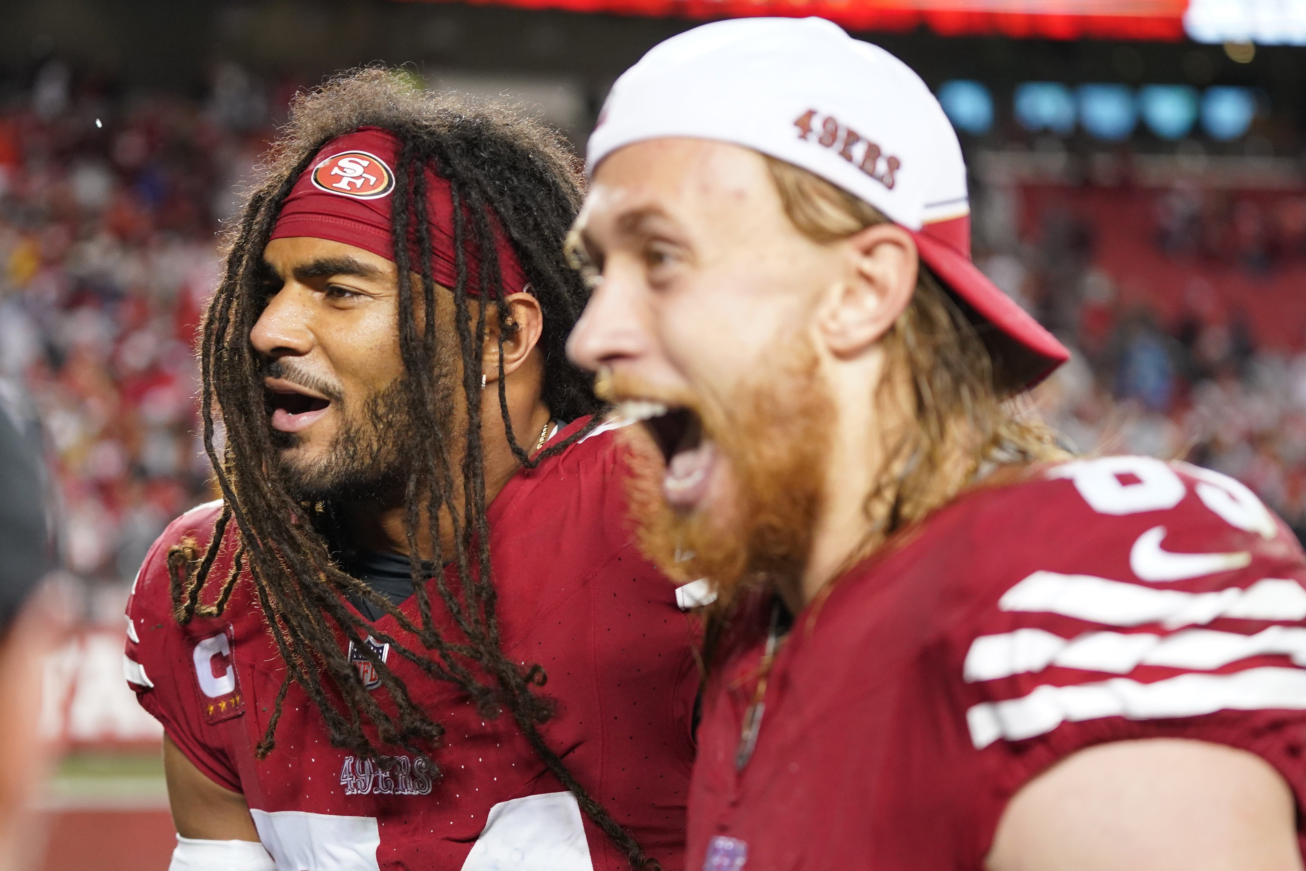 San Francisco 49ers linebacker Fred Warner (54) and tight end George Kittle (85) celebrate after defeating the Green Bay Packers in a 2024 NFC divisional round game at Levi's Stadium.