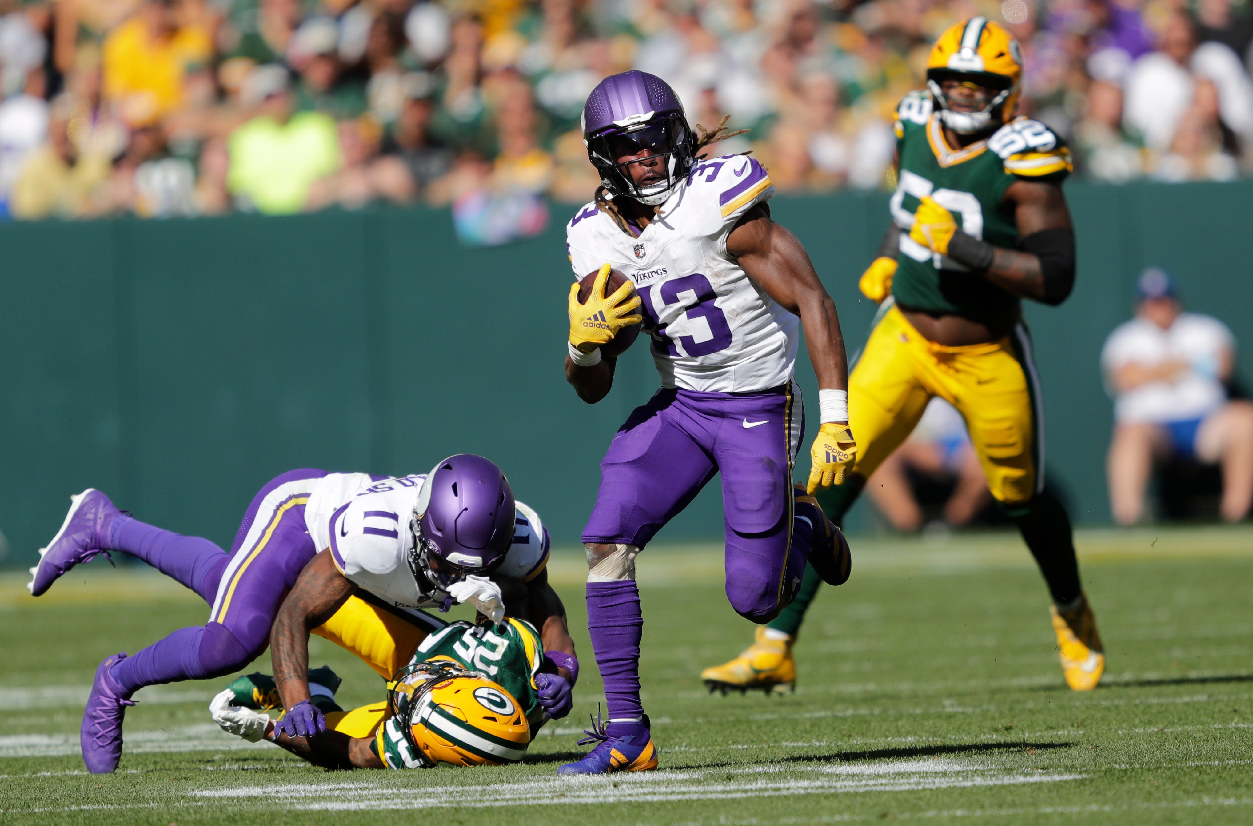 Minnesota Vikings running back Aaron Jones (33) runs for a gain against the Green Bay Packers during their football game Sunday, September 29, 2024, at Lambeau Field in Green Bay, Wisconsin.